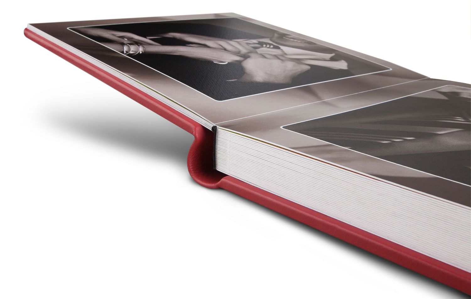 Red hardcover photo book with glossy pages open, displaying black and white photographs in a sleek modern design.