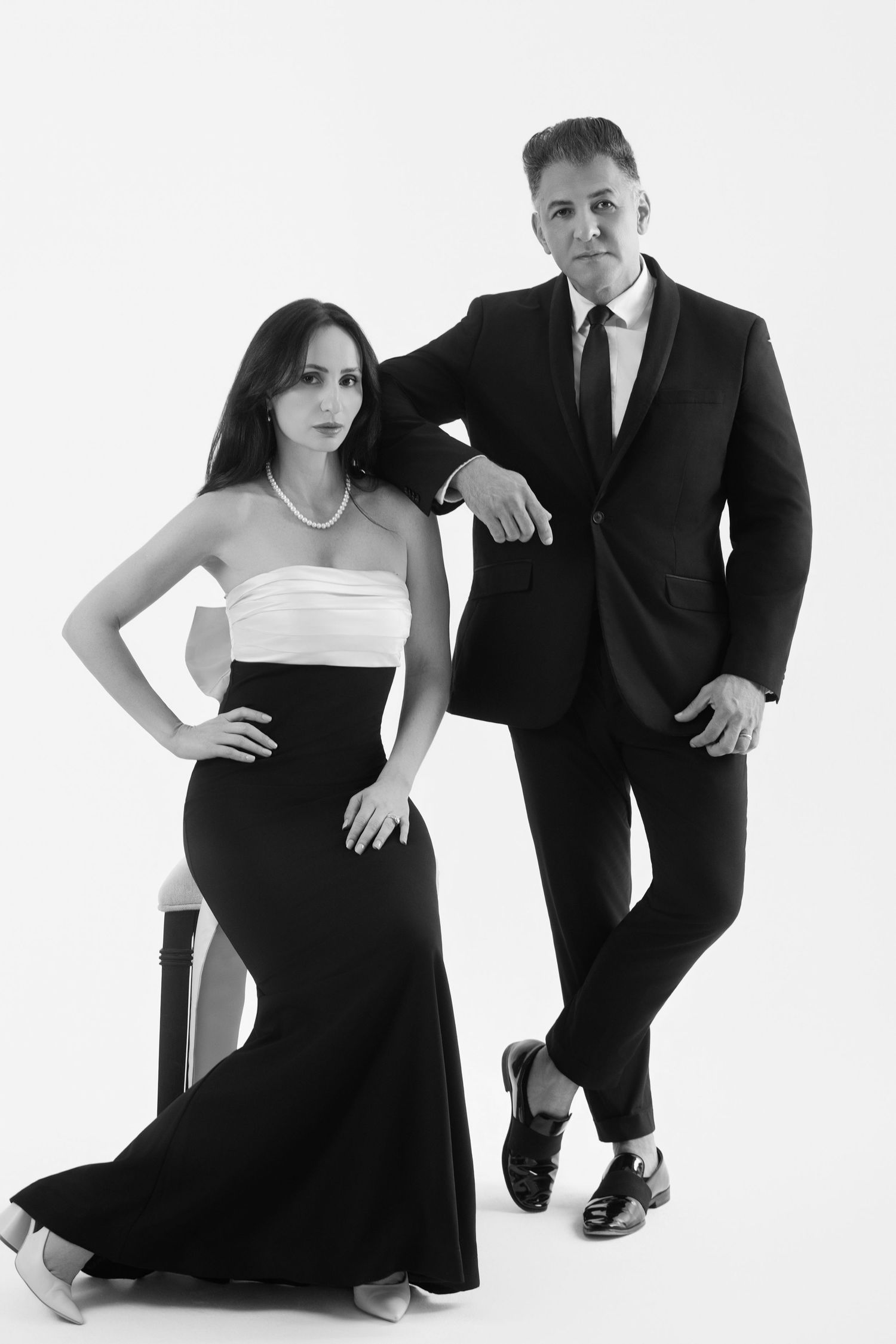 Black and white fashion photoshoot featuring elegant formal attire against white backdrop.