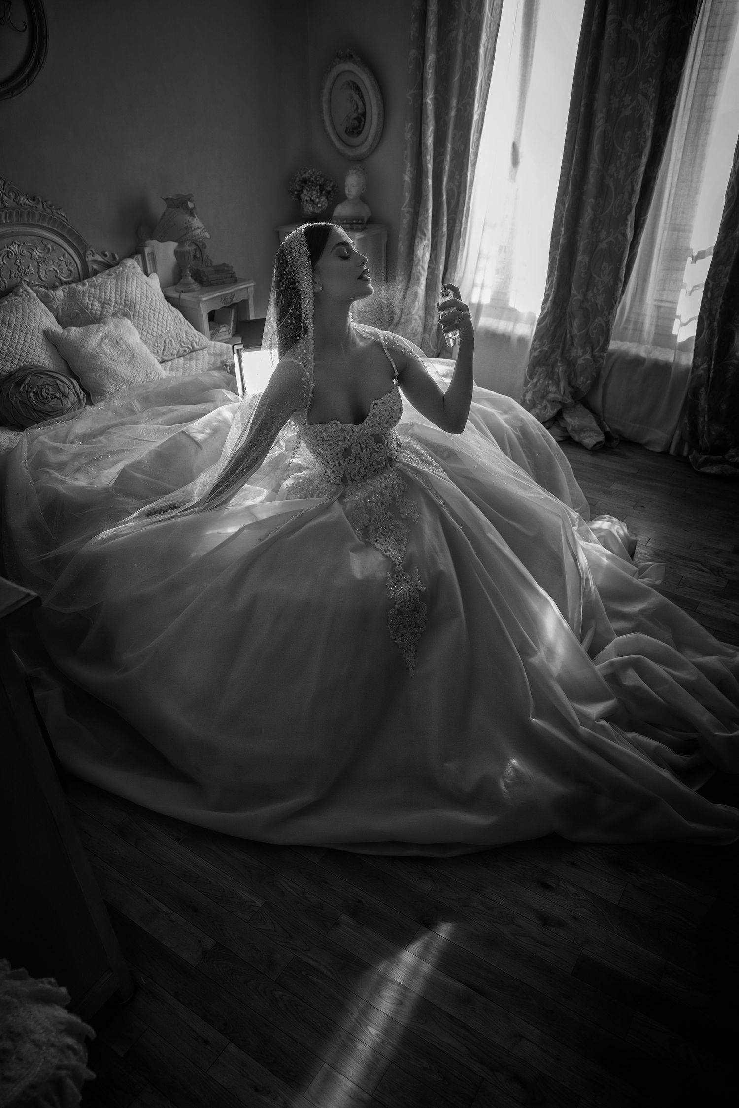 Dramatic black and white photo of a flowing wedding dress in natural window light.