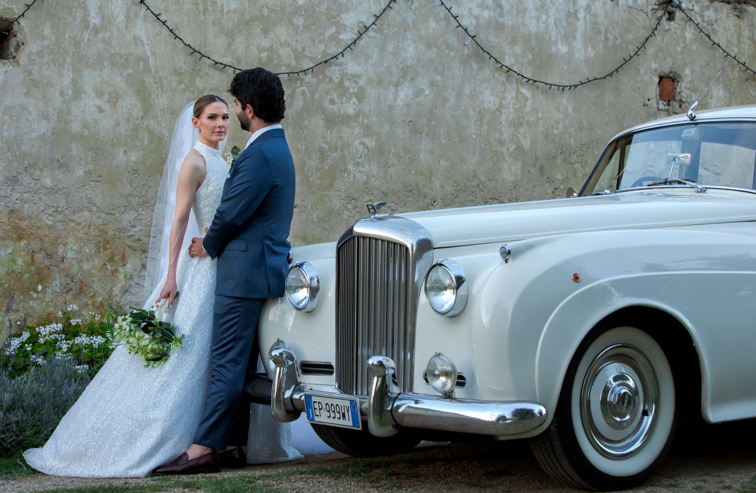 A romantic wedding photo collage featuring a classic vintage Rolls Royce car and elegant couple portraits against stone walls.