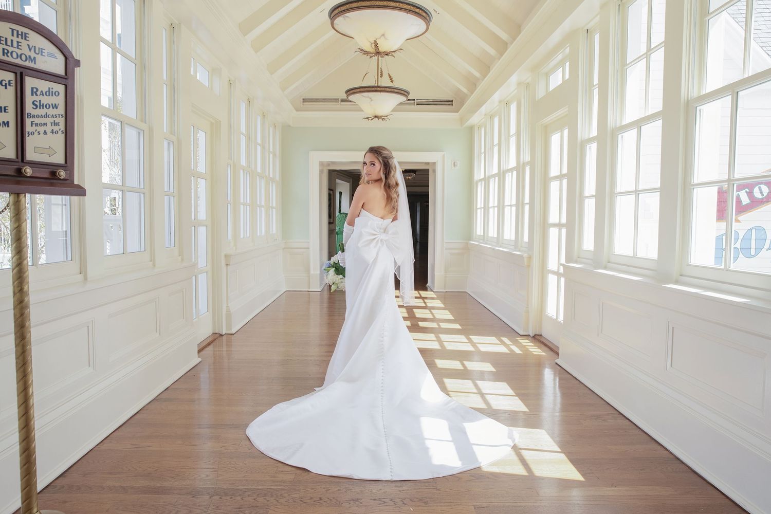A series of bridal portraits in a bright, sunlit hallway with white walls and large windows.