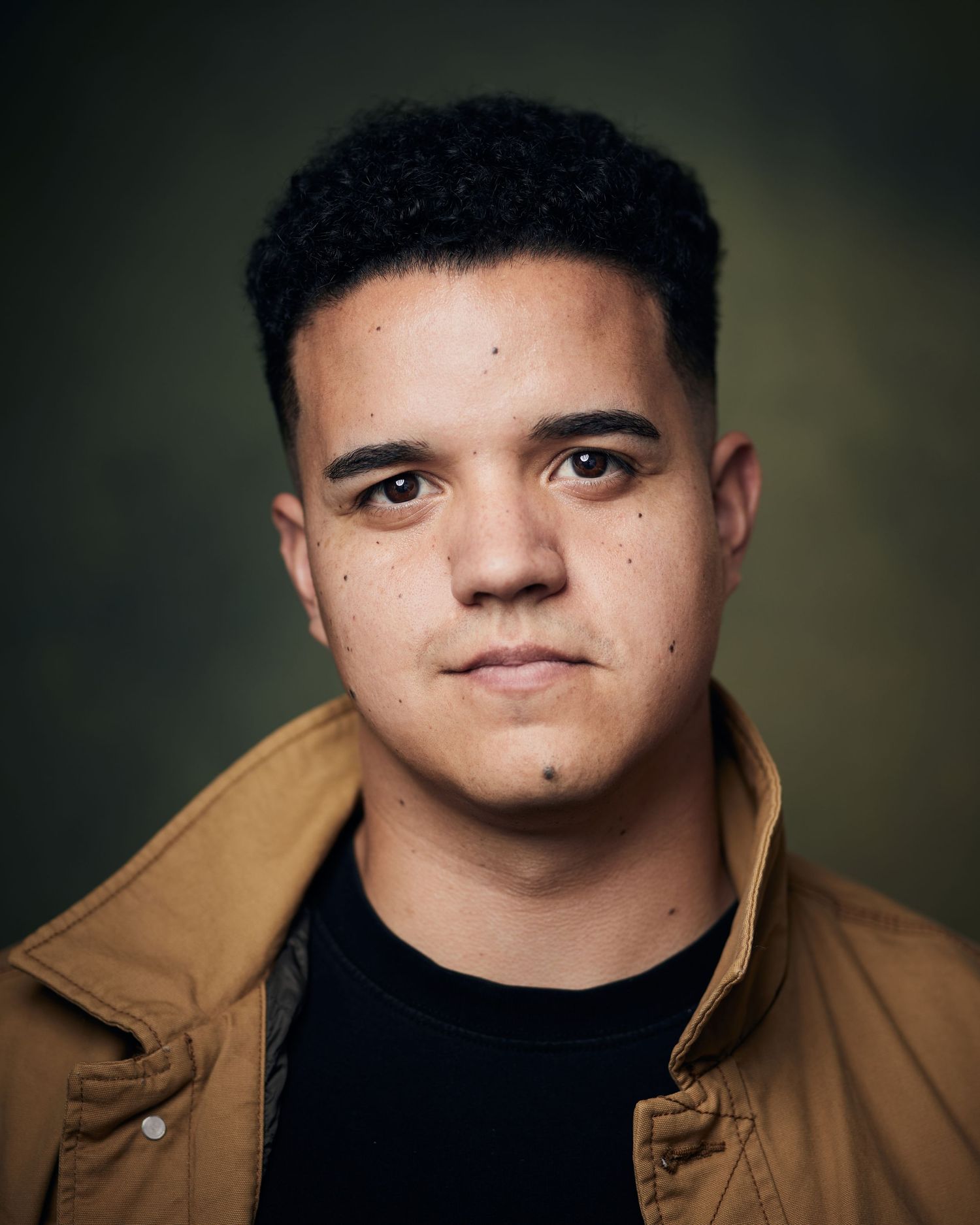 Versatile studio portrait; actor with a clean, balanced look and even lighting against a green background.