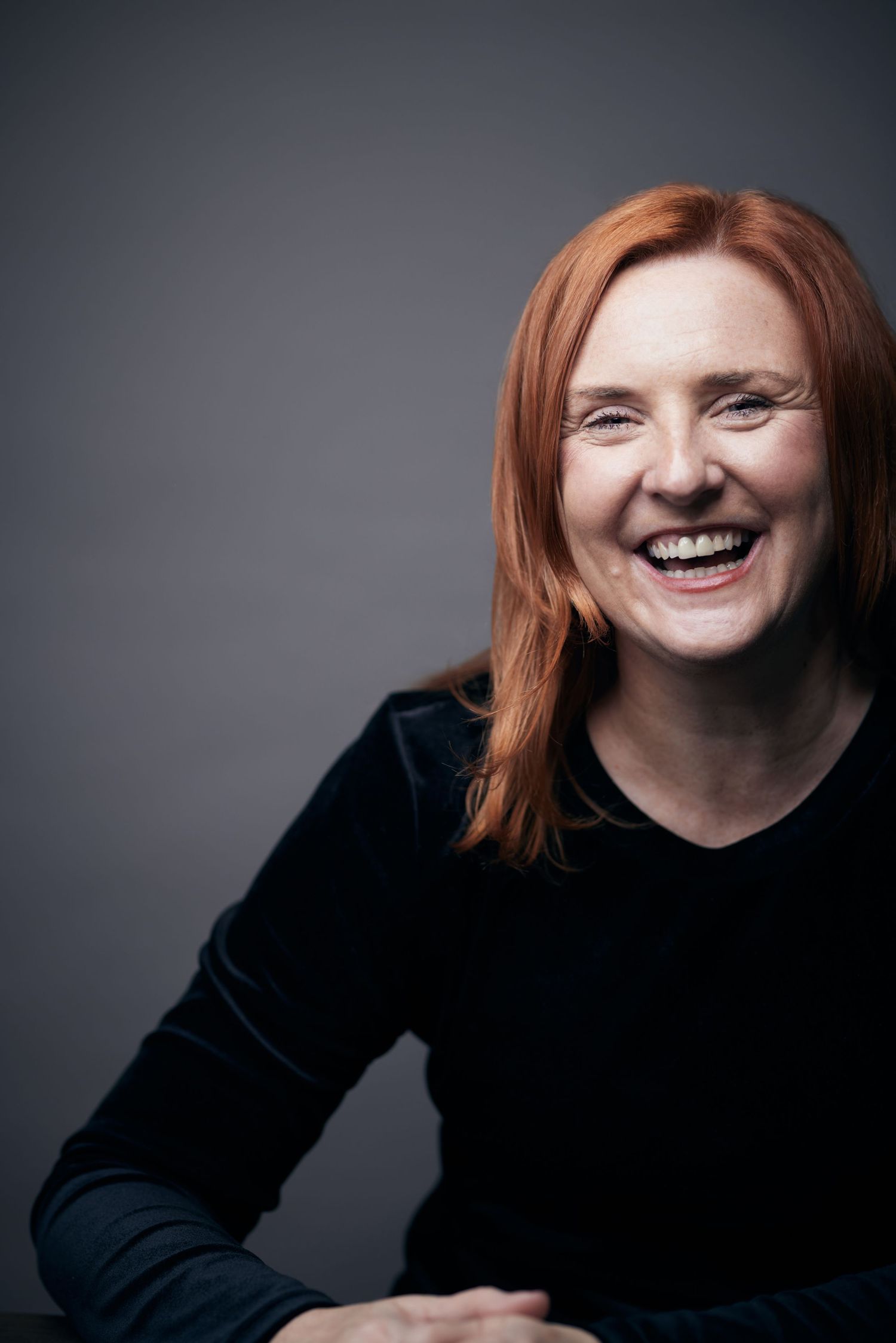 Joyful corporate portrait; business woman with a sincere, happy laugh for a Cardiff profile.