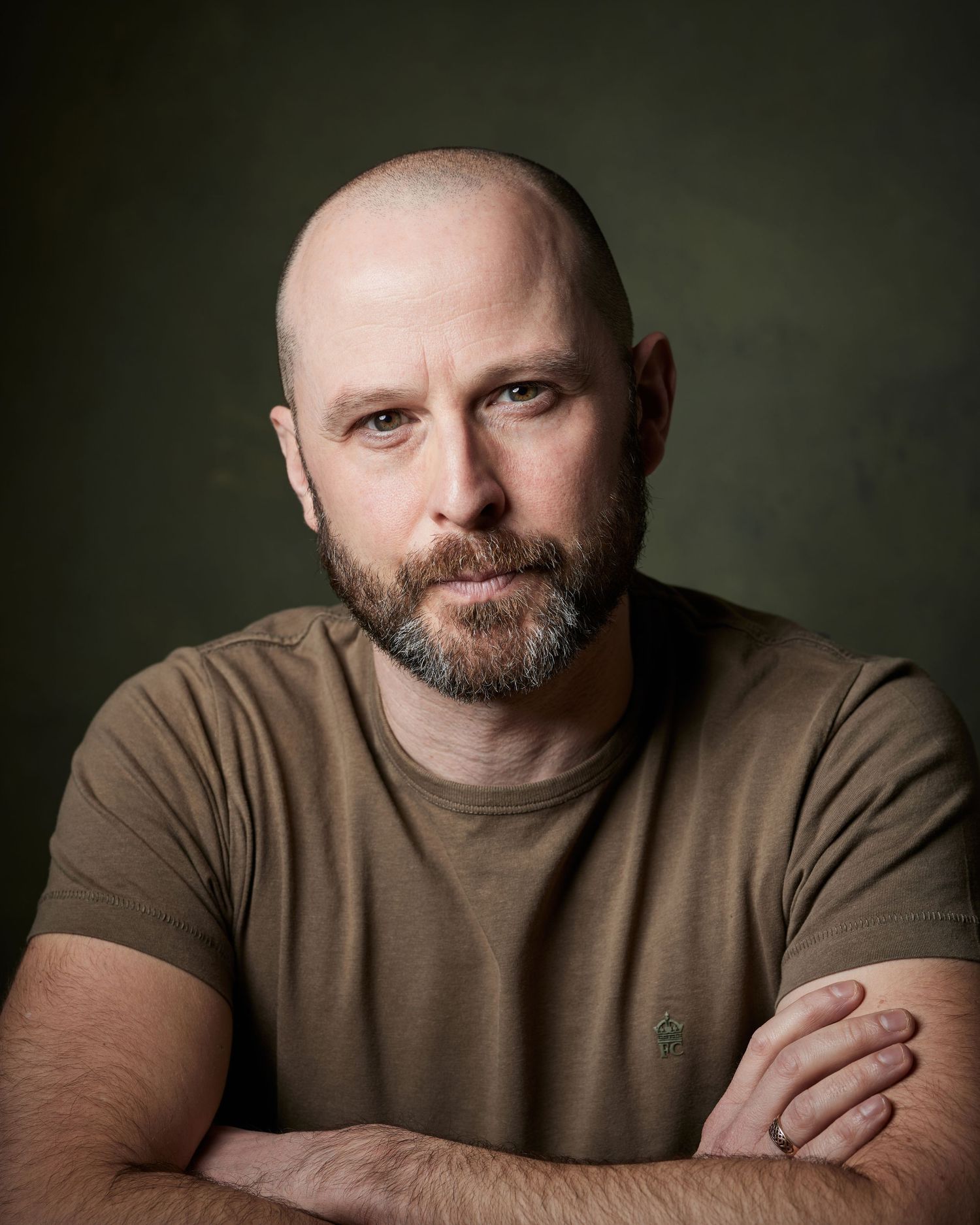 Powerful studio portrait: actor with strong eye contact looking assertively down the lens.
