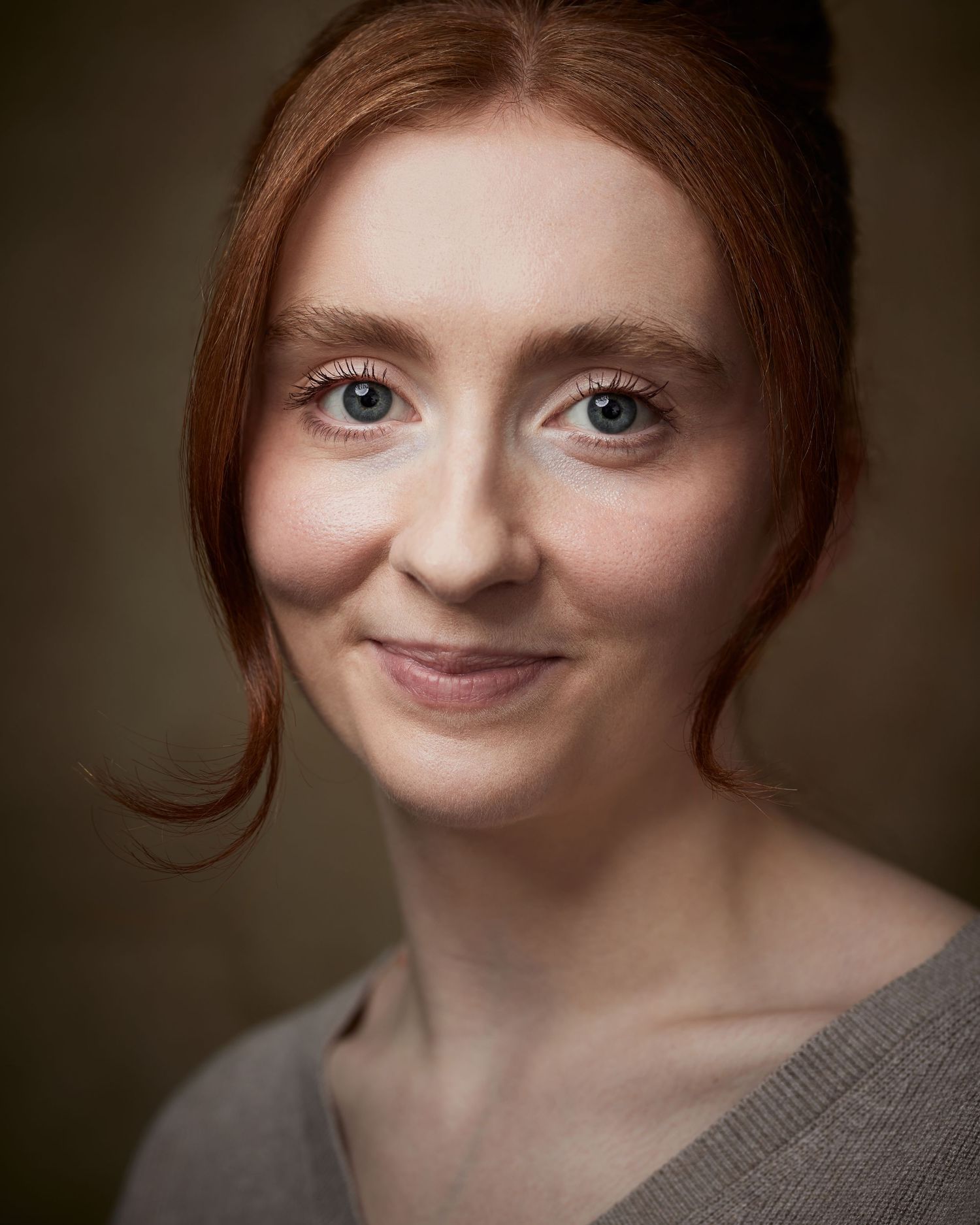 Classic headshot; female actor with a standard, high-quality industry look on brown.