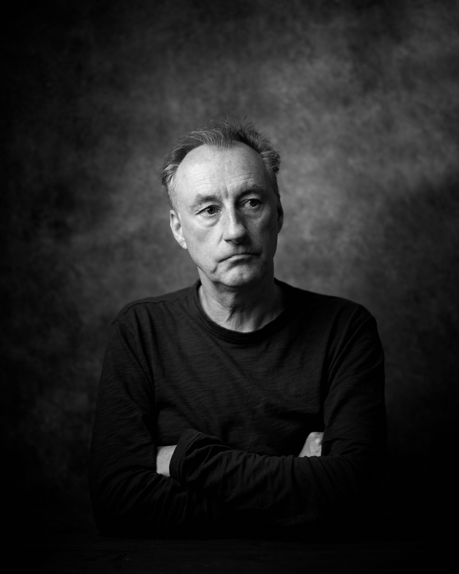 Black and white portrait of a male actor looking off-camera with a contemplative gaze.