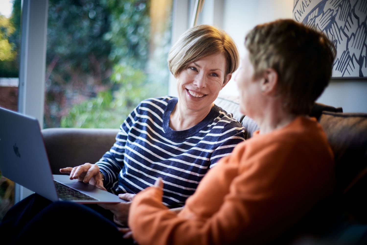 Creative professional headshot by Geraint Todd; woman engaged in a discussion with a client with a warm, approachable energy.