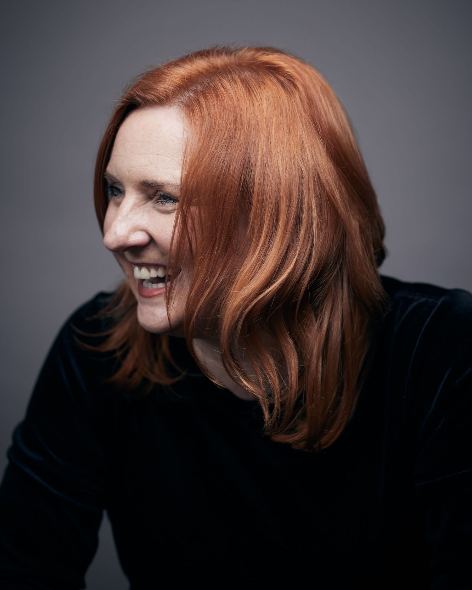 Happy professional headshot; woman with laughing in between photographs by Cardiff photographer Geraint Todd.