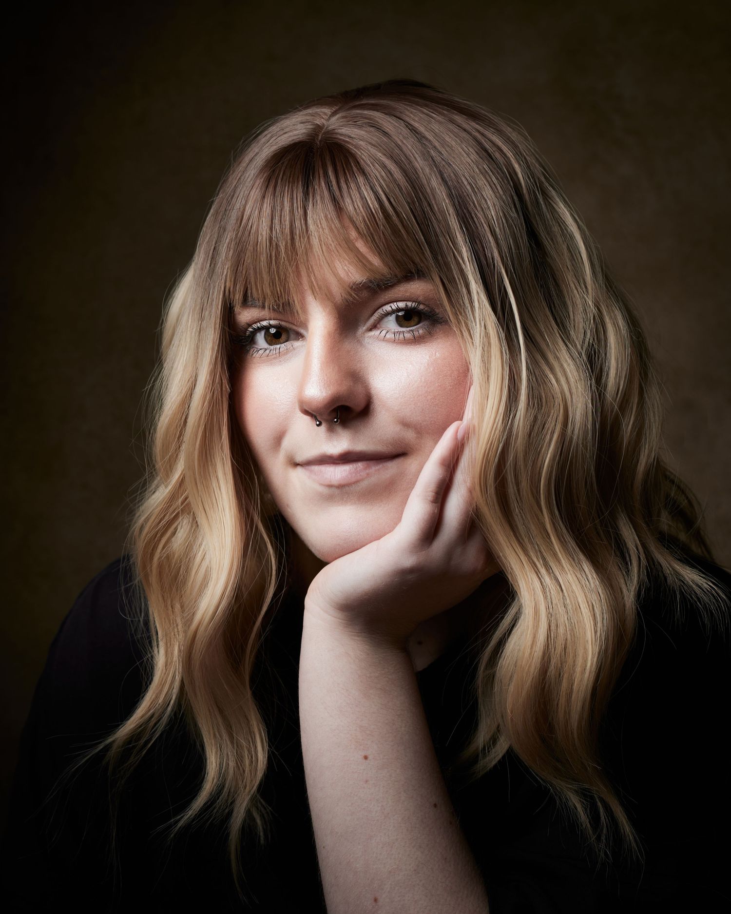 Studio portrait; actress with a warm, friendly smile and engaging eyes.