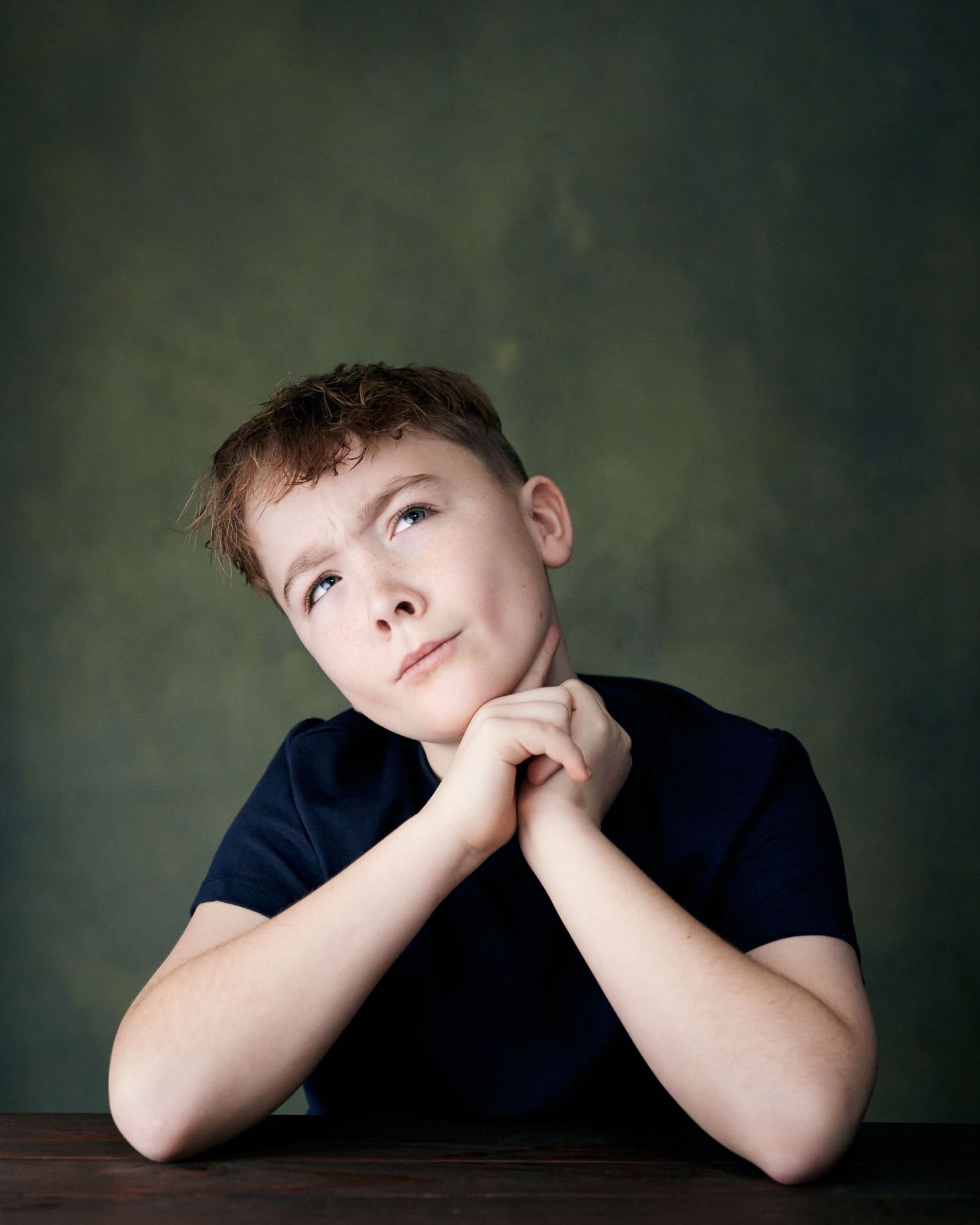 Studio portrait; young actor with a curious head tilt and a comedic, wondering expression.
