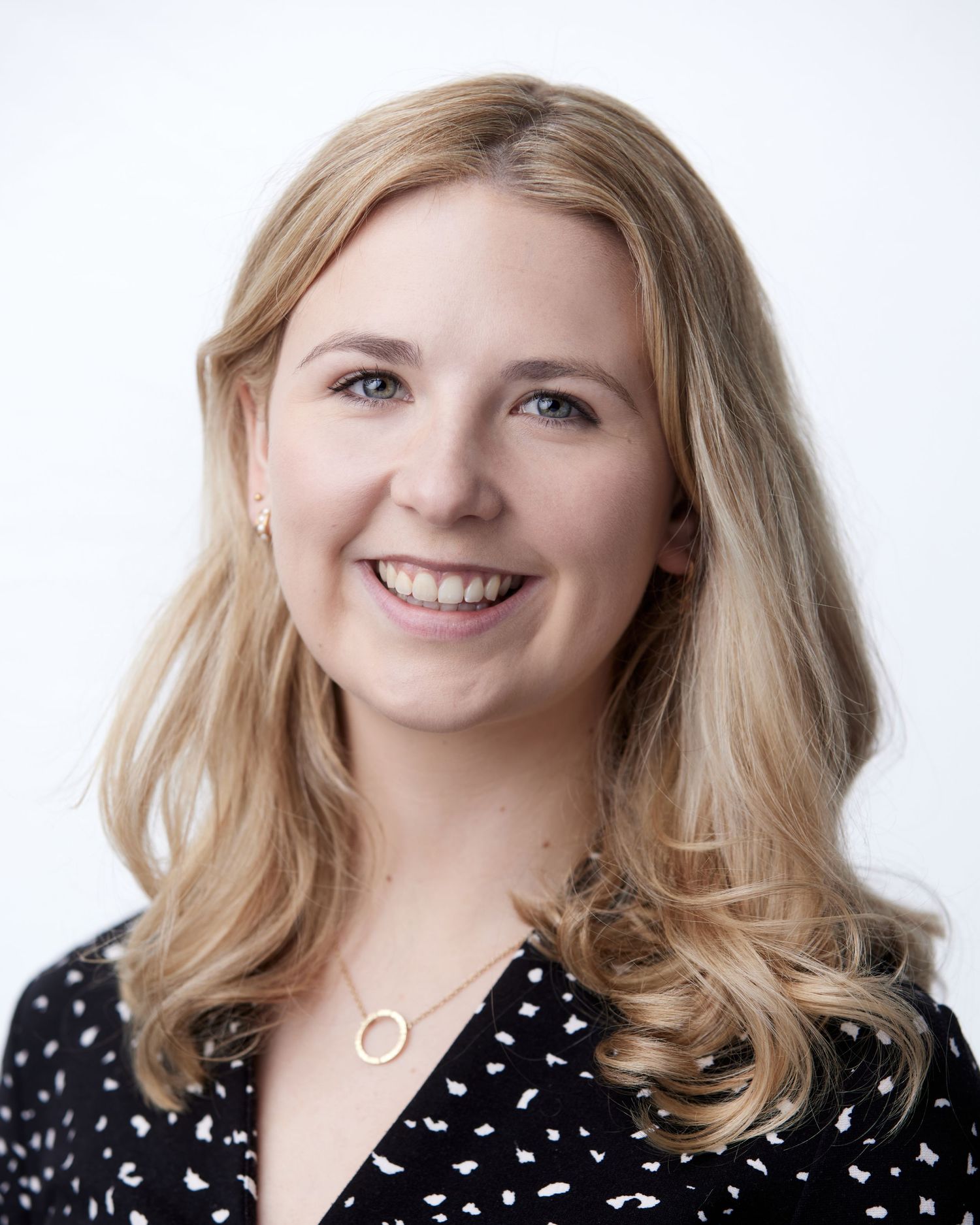 Friendly business headshot by Geraint Todd; woman in a black and white polka dot top with a bright, welcoming smile and blonde wavy hair.