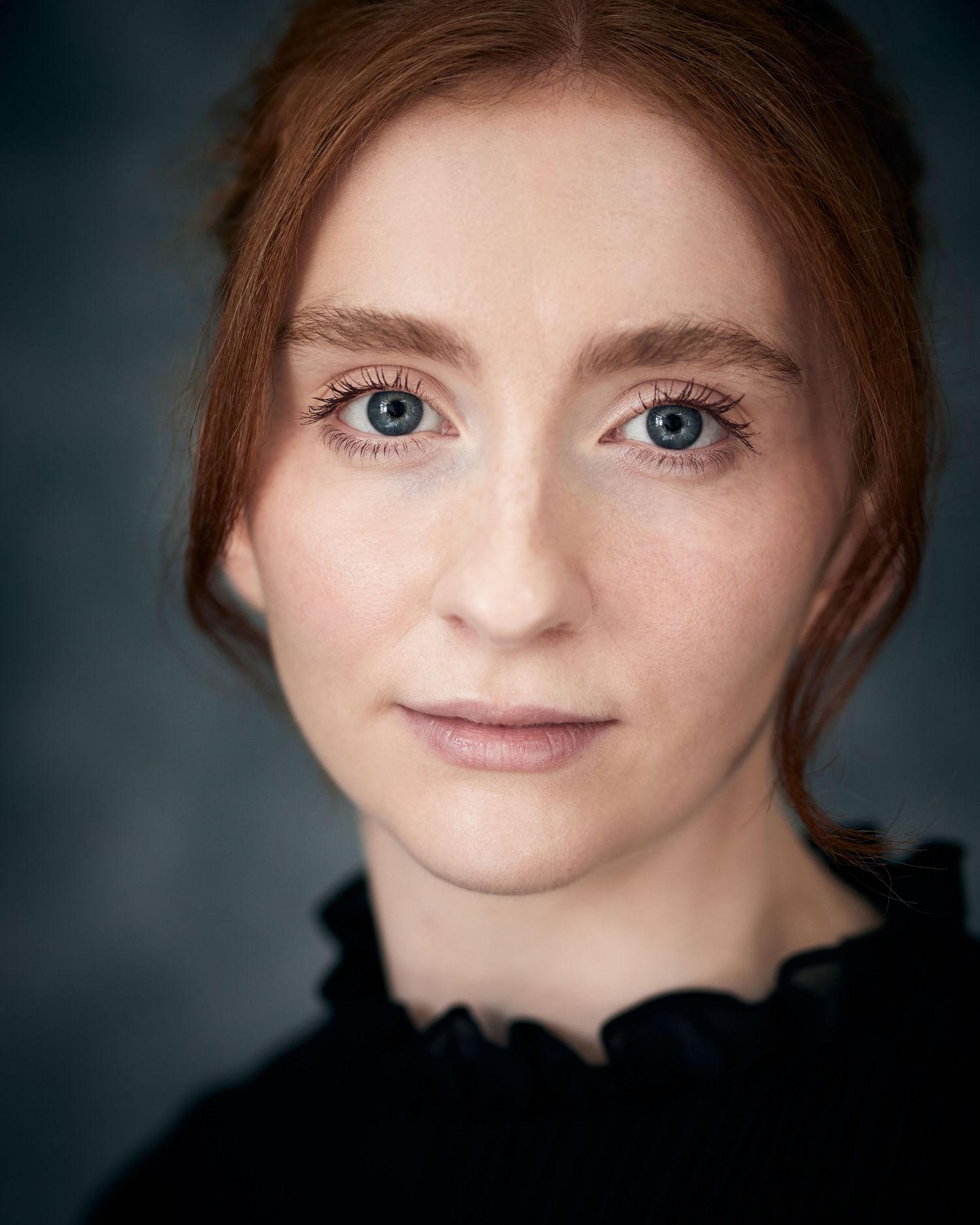 A period-style actor headshot of a femal actress with soft focus and a gentle, vulnerable expression.
