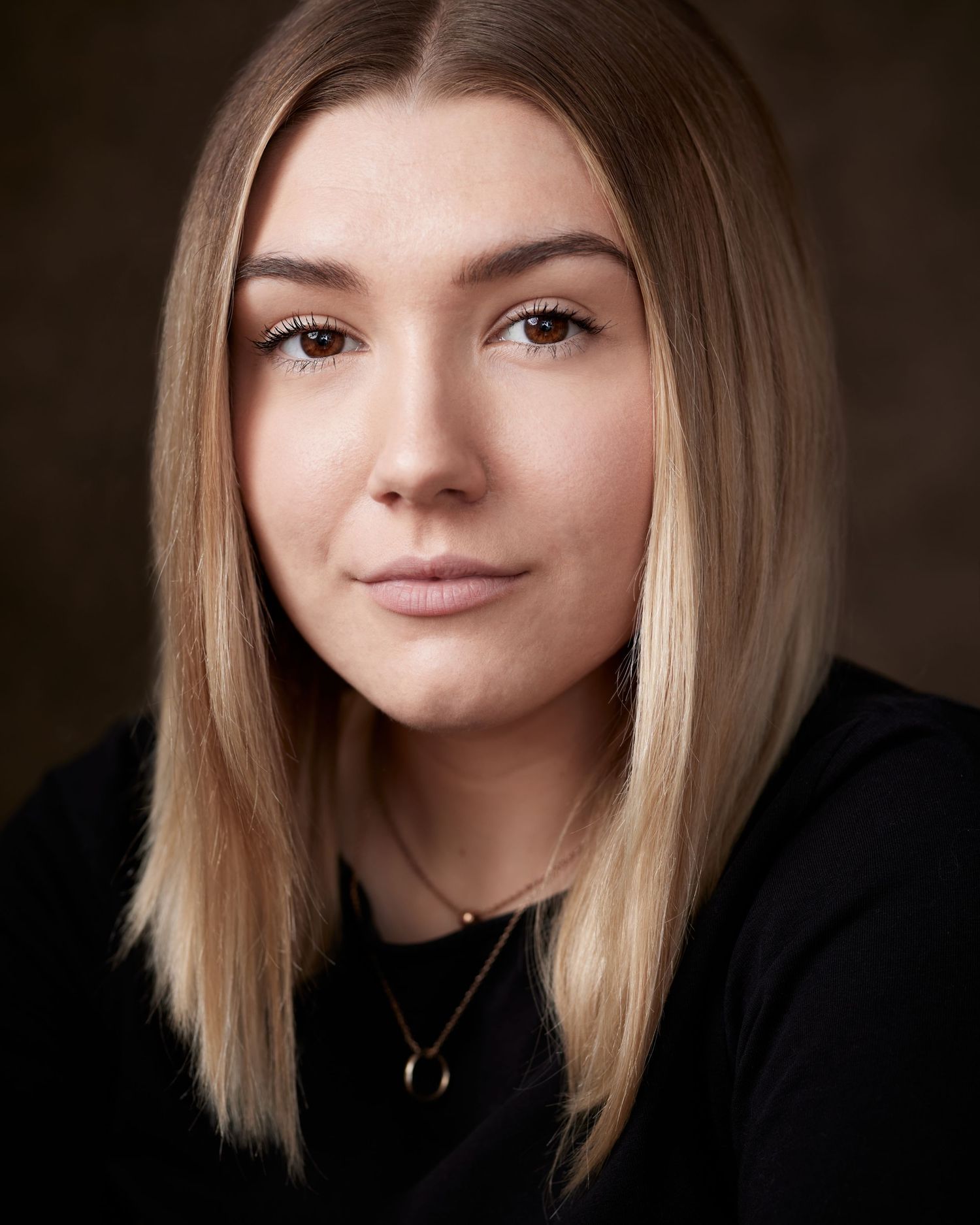 Close-up of a female performer with a focused, determined look and studio lighting.