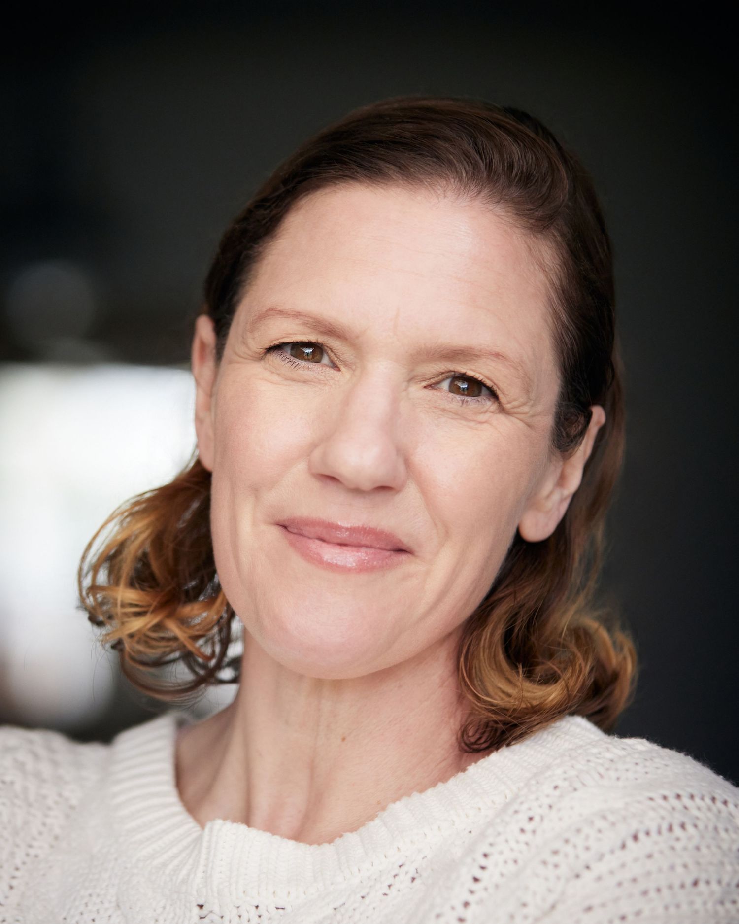 Accessible natural light portrait; actress with a warm, honest smile.