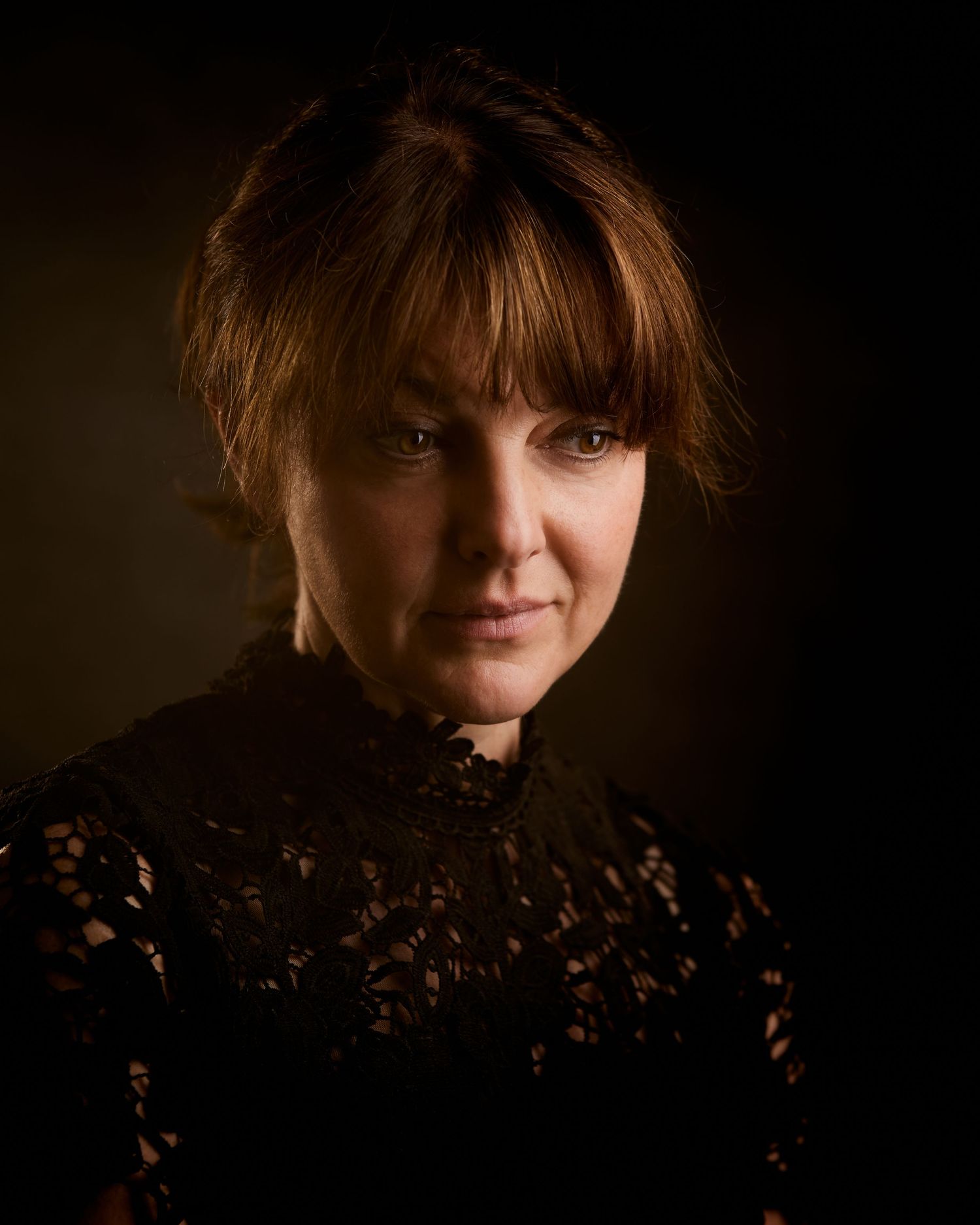 Period-lead portrait; actress with a timeless look in a Cardiff studio, lit with low key lighting.
