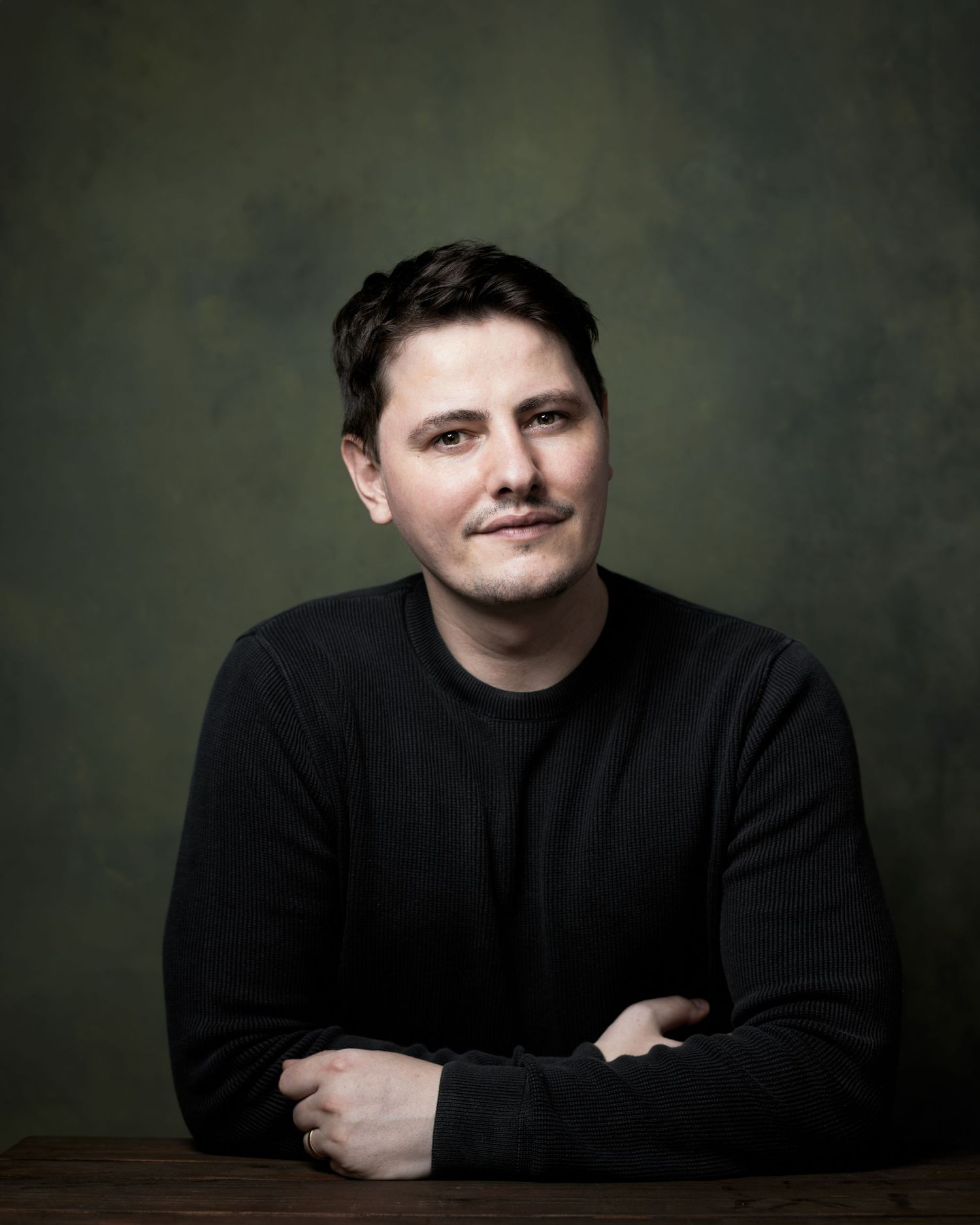 Captivating character portrait; man with an intense and charismatic look against a green background.