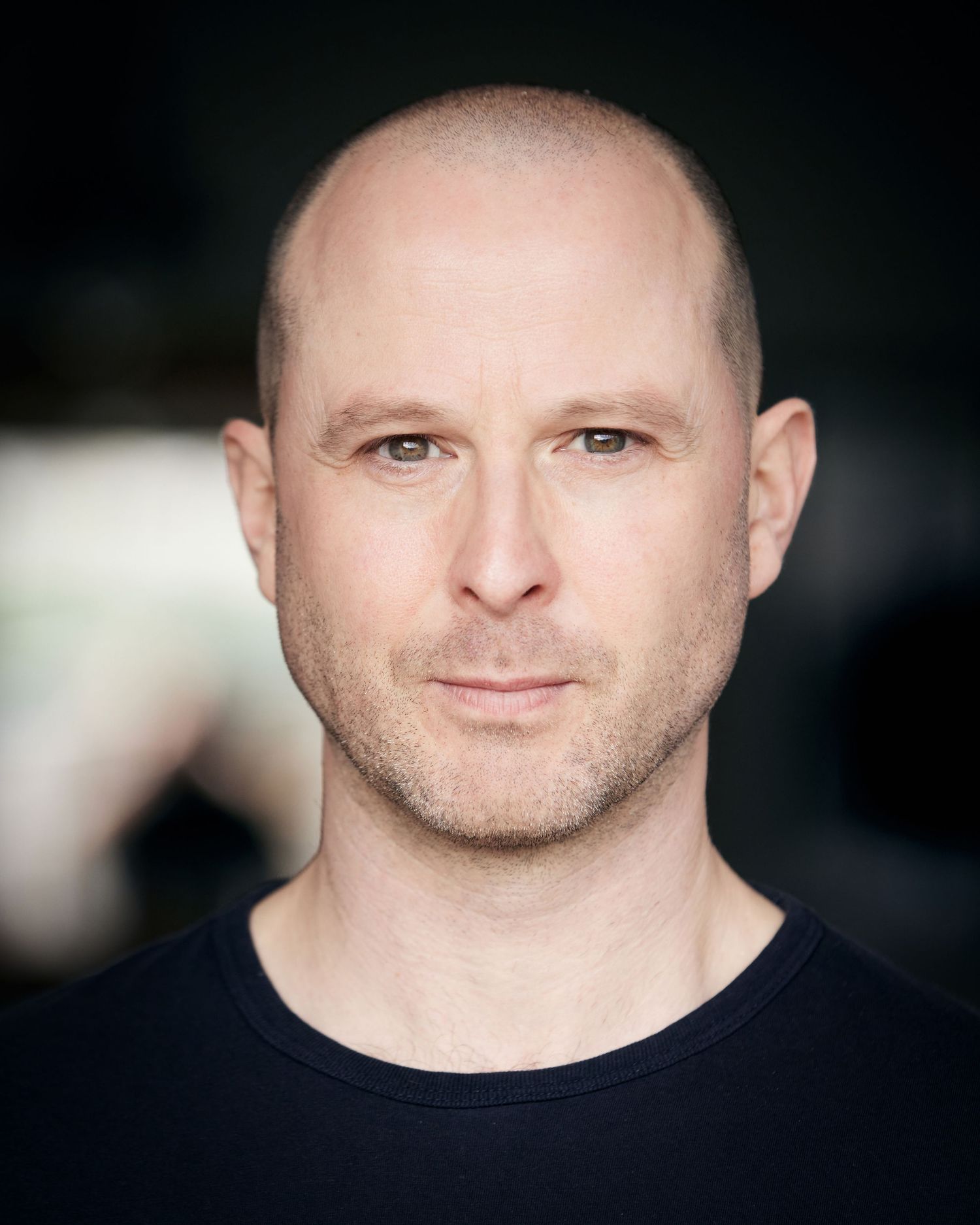 Cardiff outdoor headshot; powerful and strong character expression with direct eye contact in natural light.