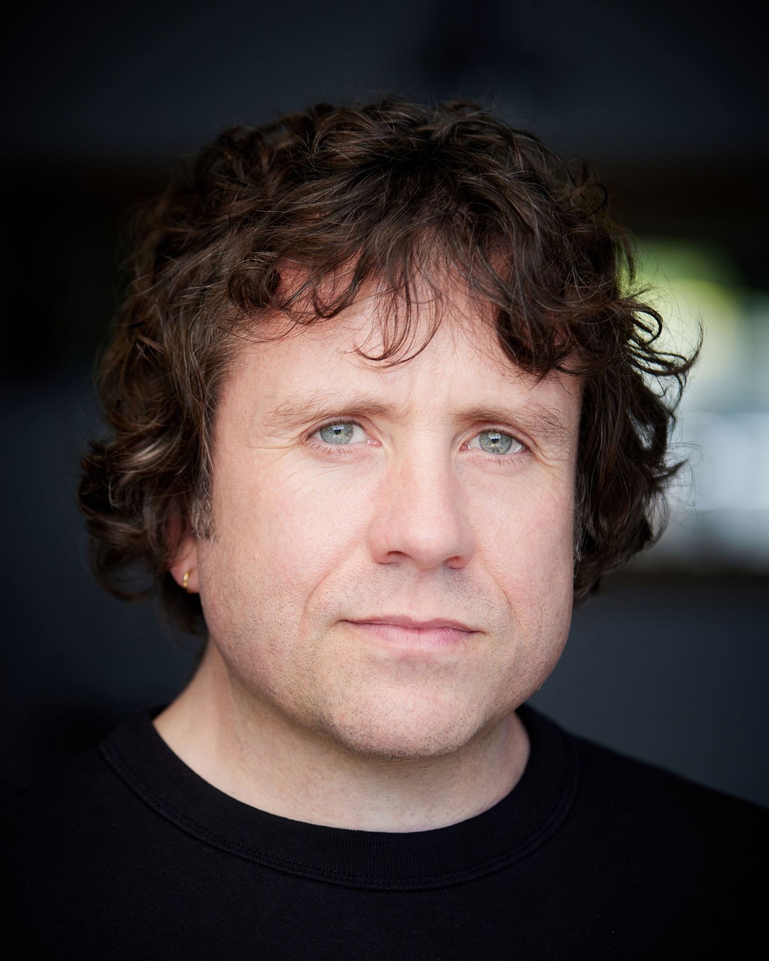 Authentic actor portrait; unforced neutral expression in Cardiff natural light.