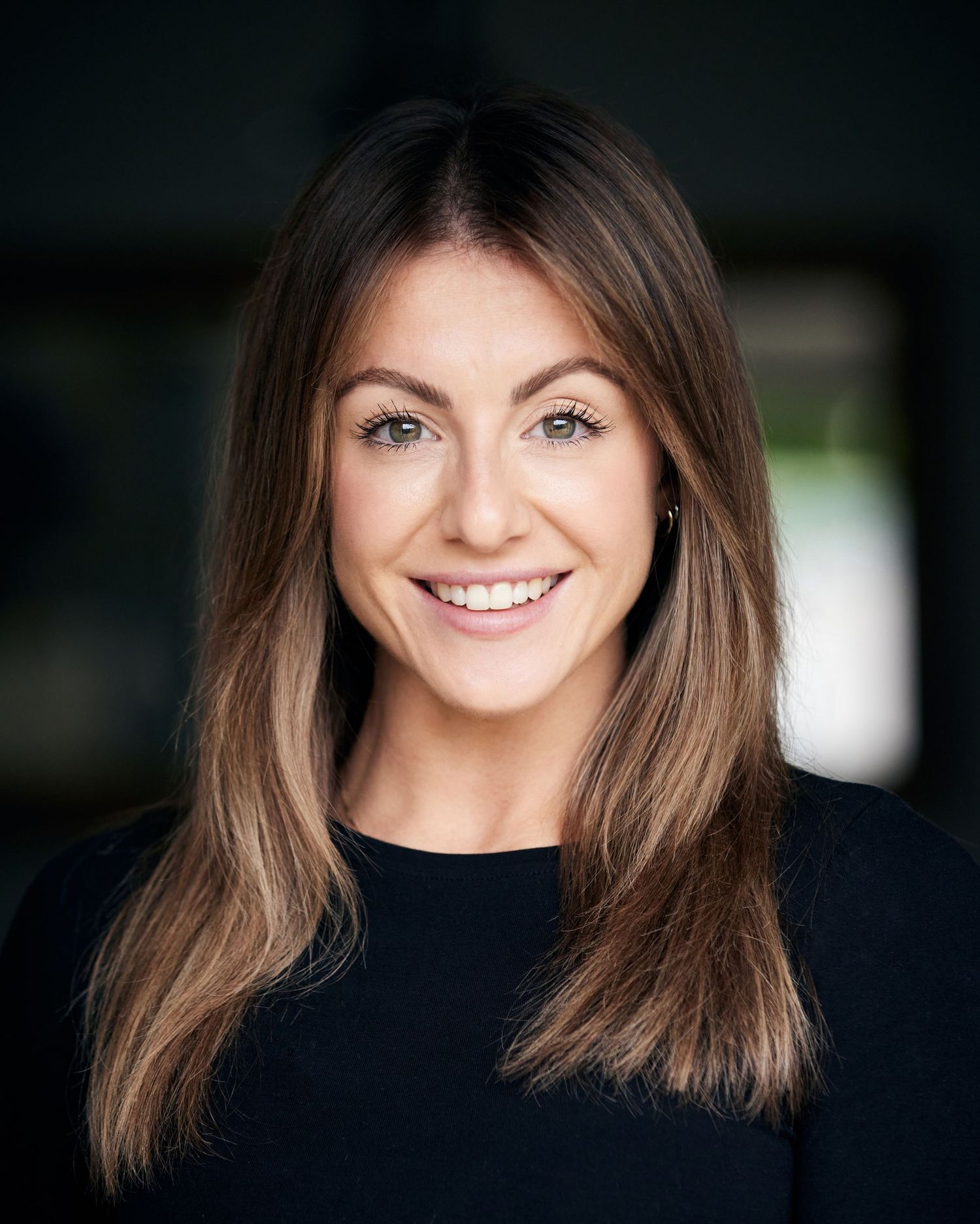 Commercial Cardiff headshot by Geraint Todd; bright, energetic smile in natural light with bokeh.