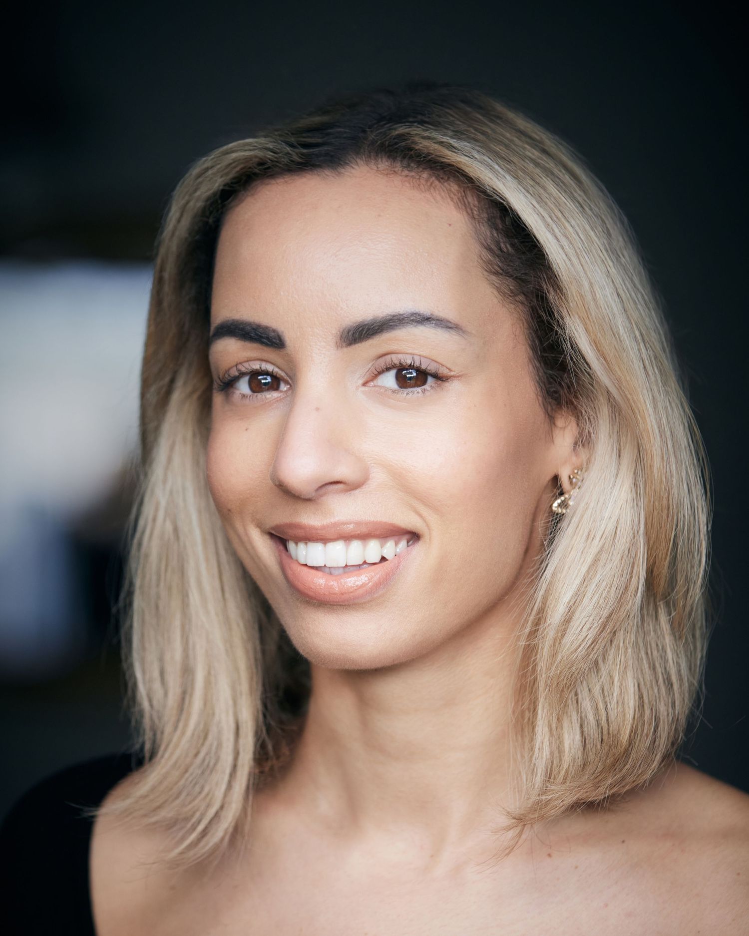 Bright-eyed friendly headshot; actress with a warm Cardiff natural light look.