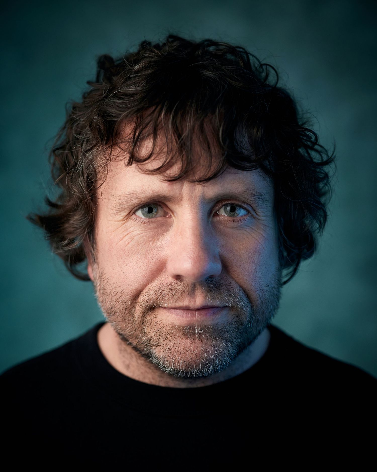 Cinematic headshot; actor with a heavy, contemplative energy and  mixed lighting.