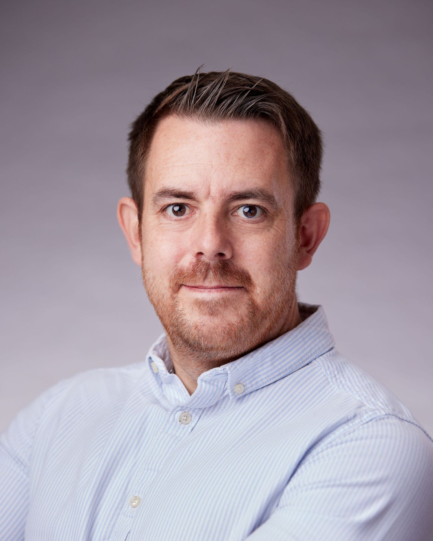 Strong corporate portrait; businessman with an authoritative presence in a Cardiff studio.