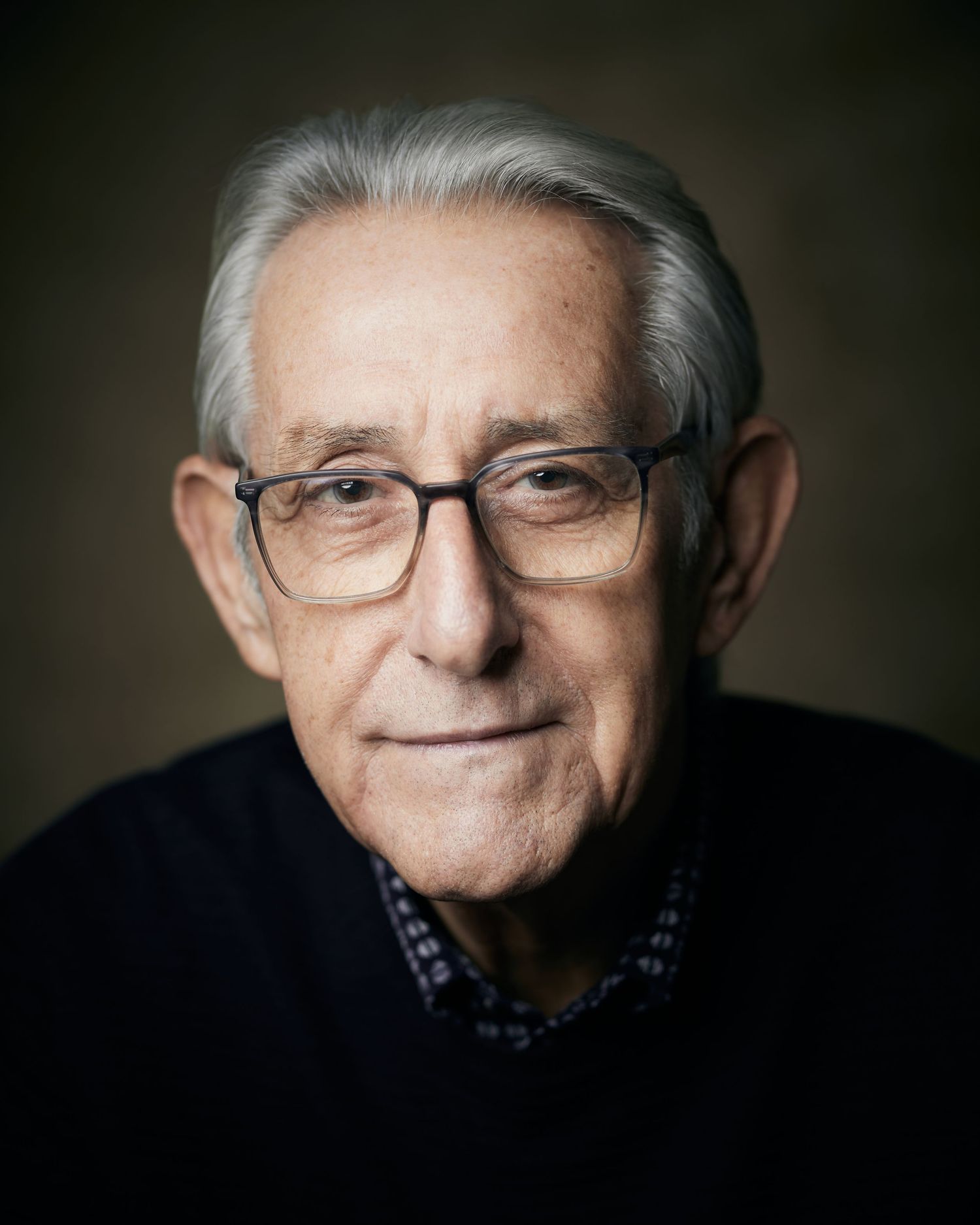 Charismatic studio headshot; male performer with a witty and gentle look.