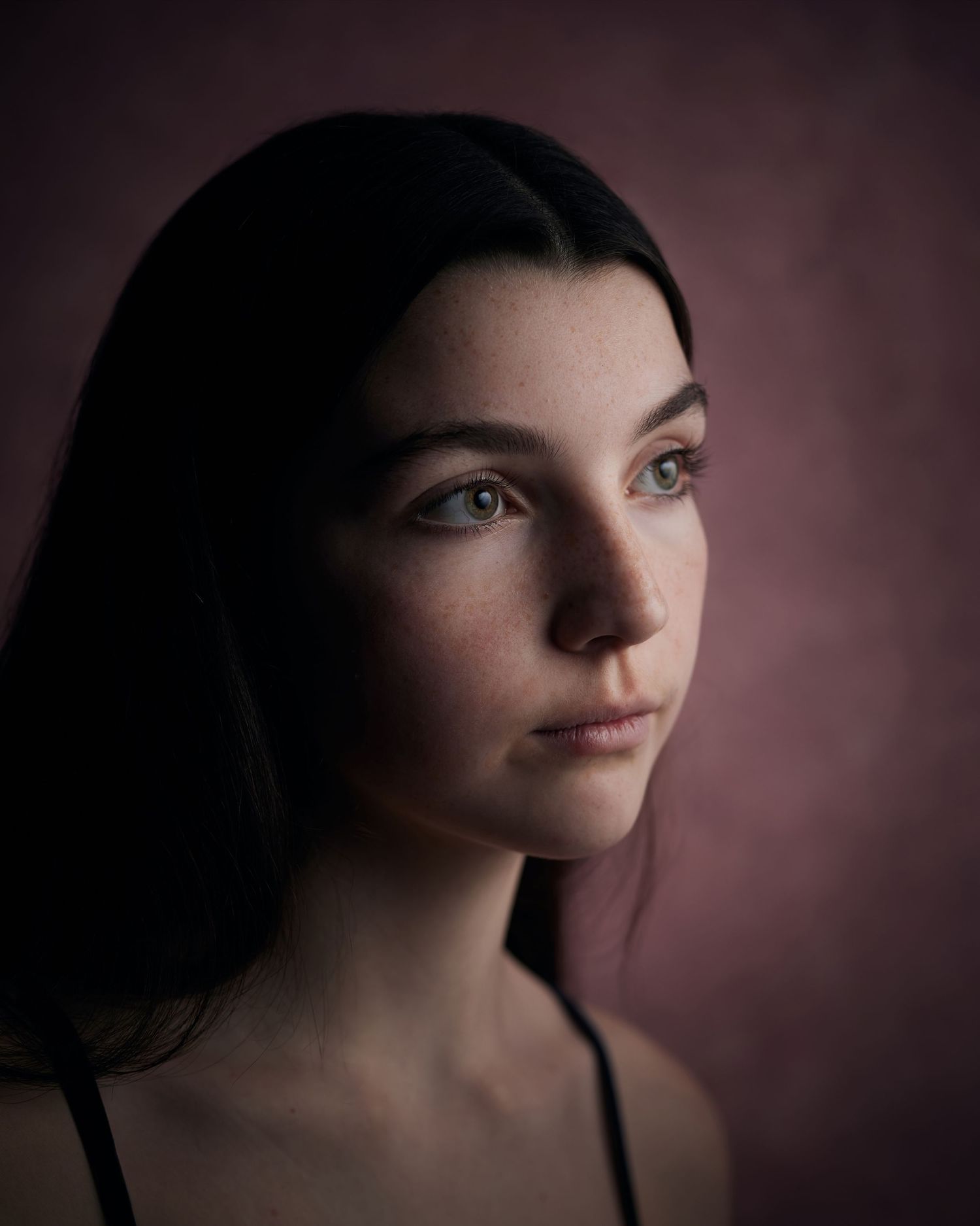 Ethereal headshot; young actress with a soft, romantic-period look on a pink canvas.