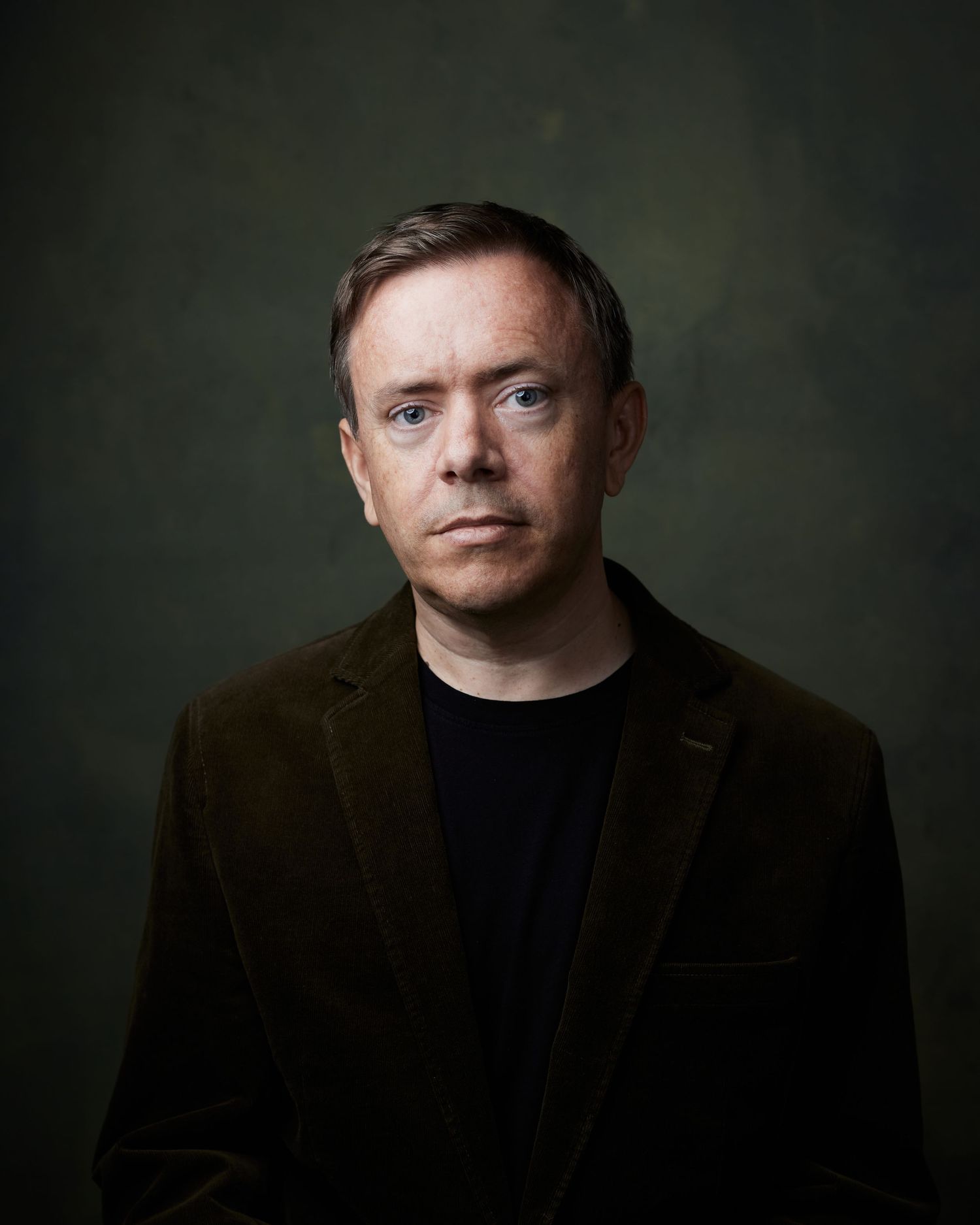 Balanced studio portrait; actor with a smart, capable, and open facial expression.