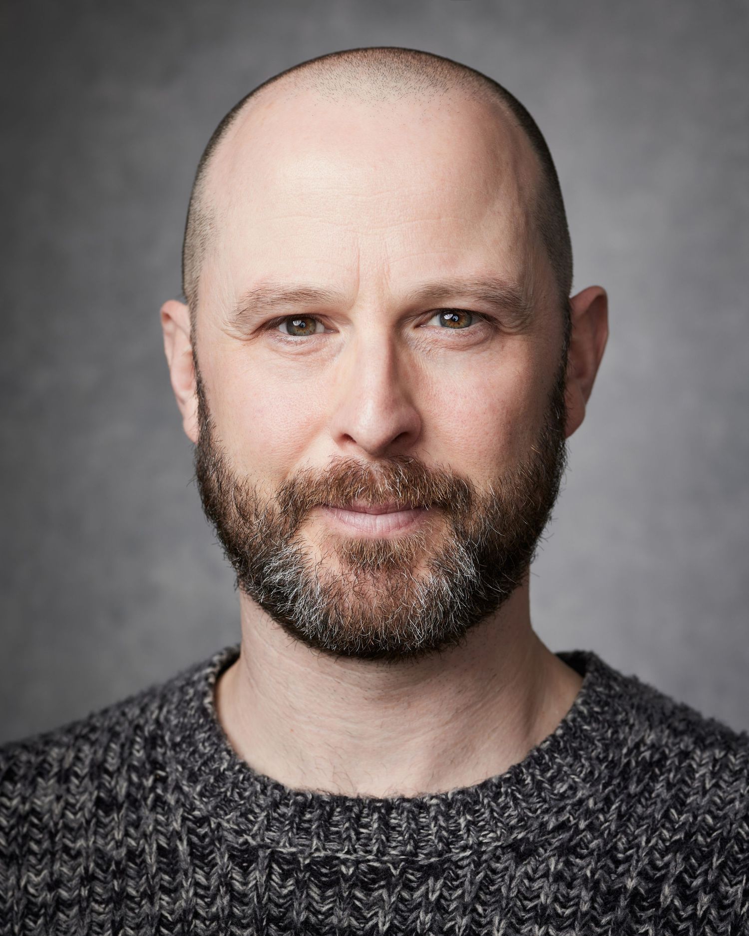 Dramatic close-up; male performer with a focused, confident energy and grit.