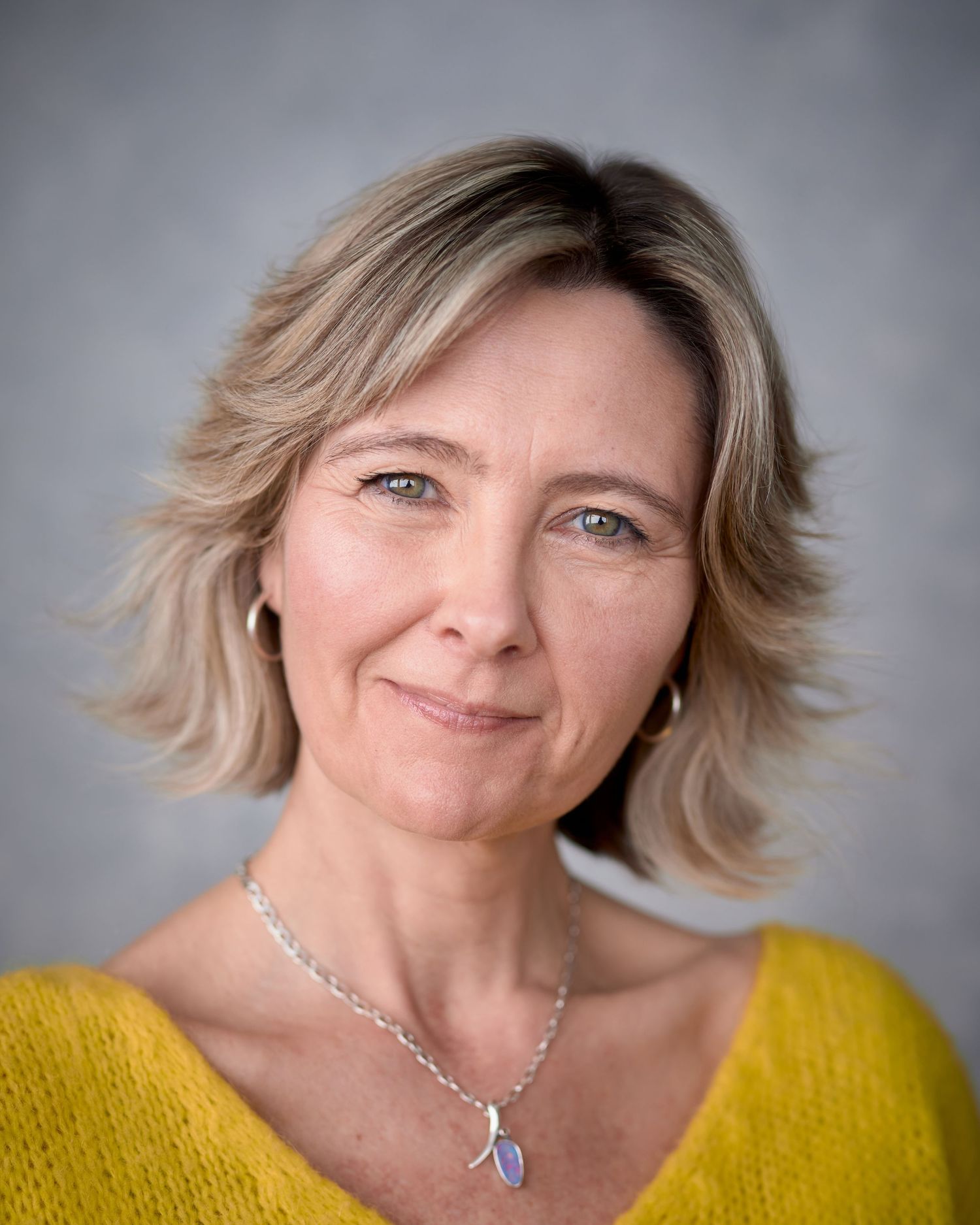 Approachable and friendly commercial headshot of actress Noni Lewis. Warm studio lighting, Cardiff headshot photography session.