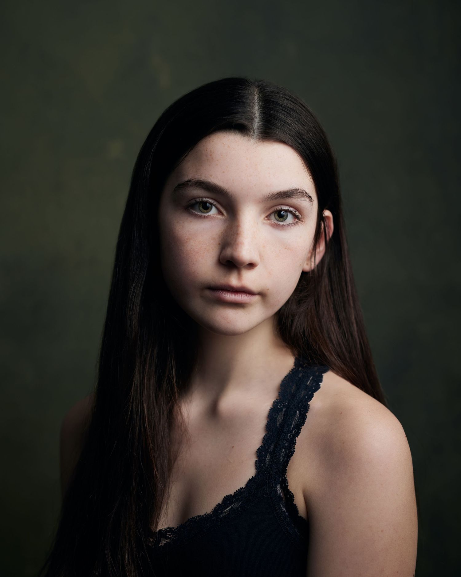 Sophisticated period portrait; girl with an elegant, refined presence on green.