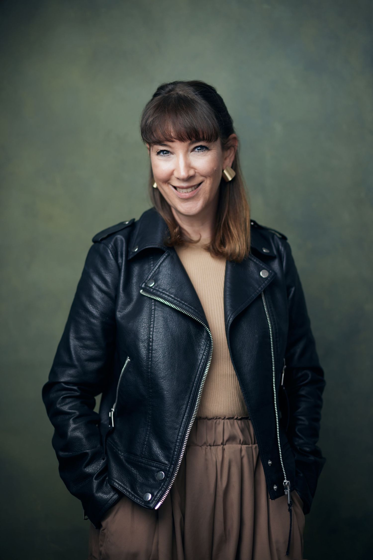 Engaging Cardiff business portrait; woman with a charismatic, knowing smile and direct professional gaze.
