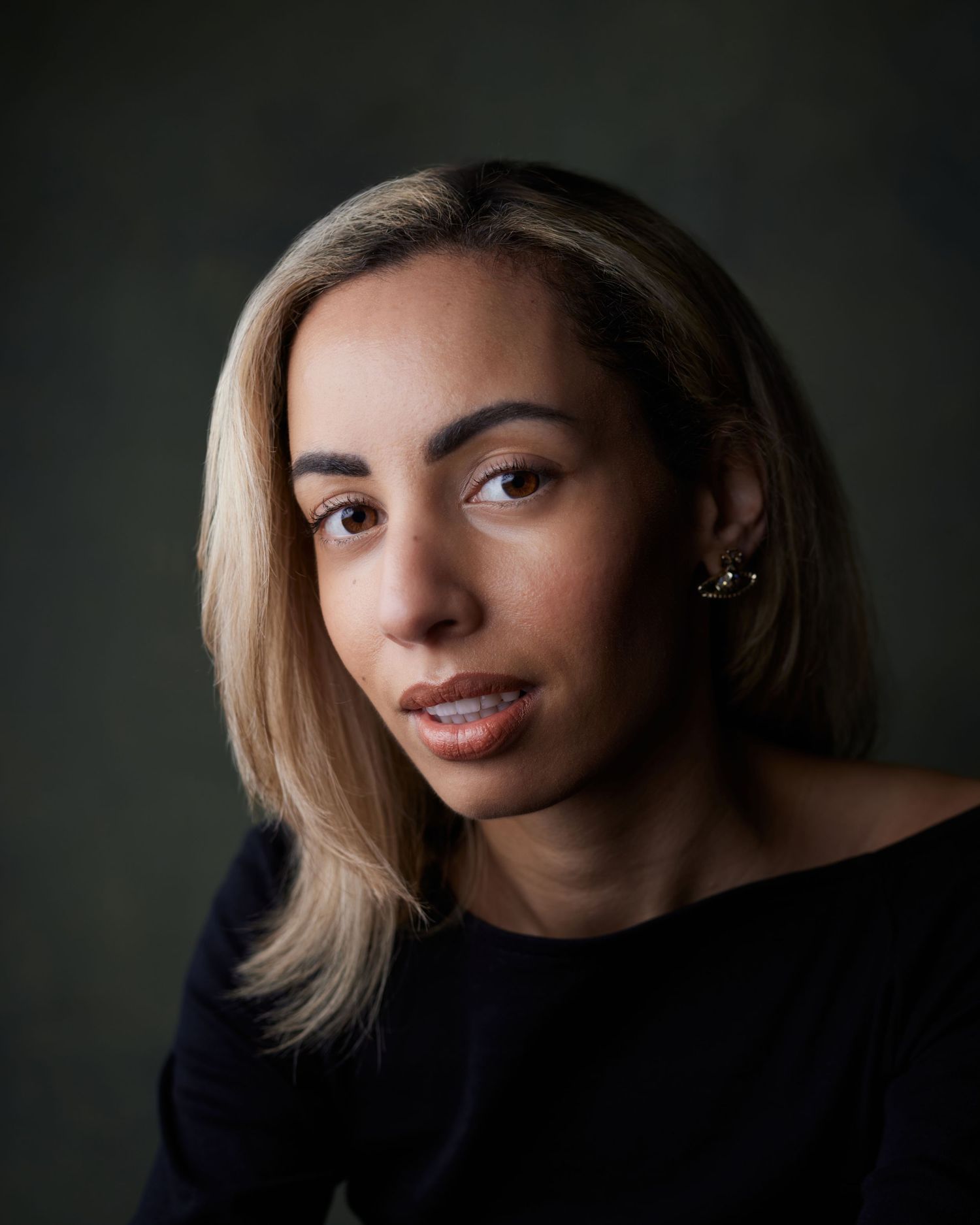 Warm studio headshot; actress in a knit sweater with a gentle, approachable gaze.