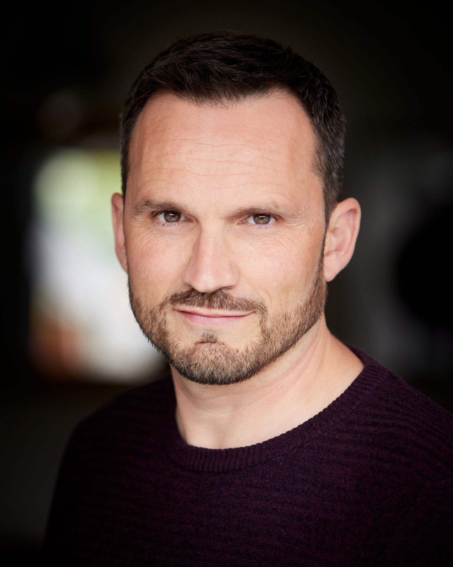 Deep, intense headshot; pensive and strong energy in Cardiff natural light.