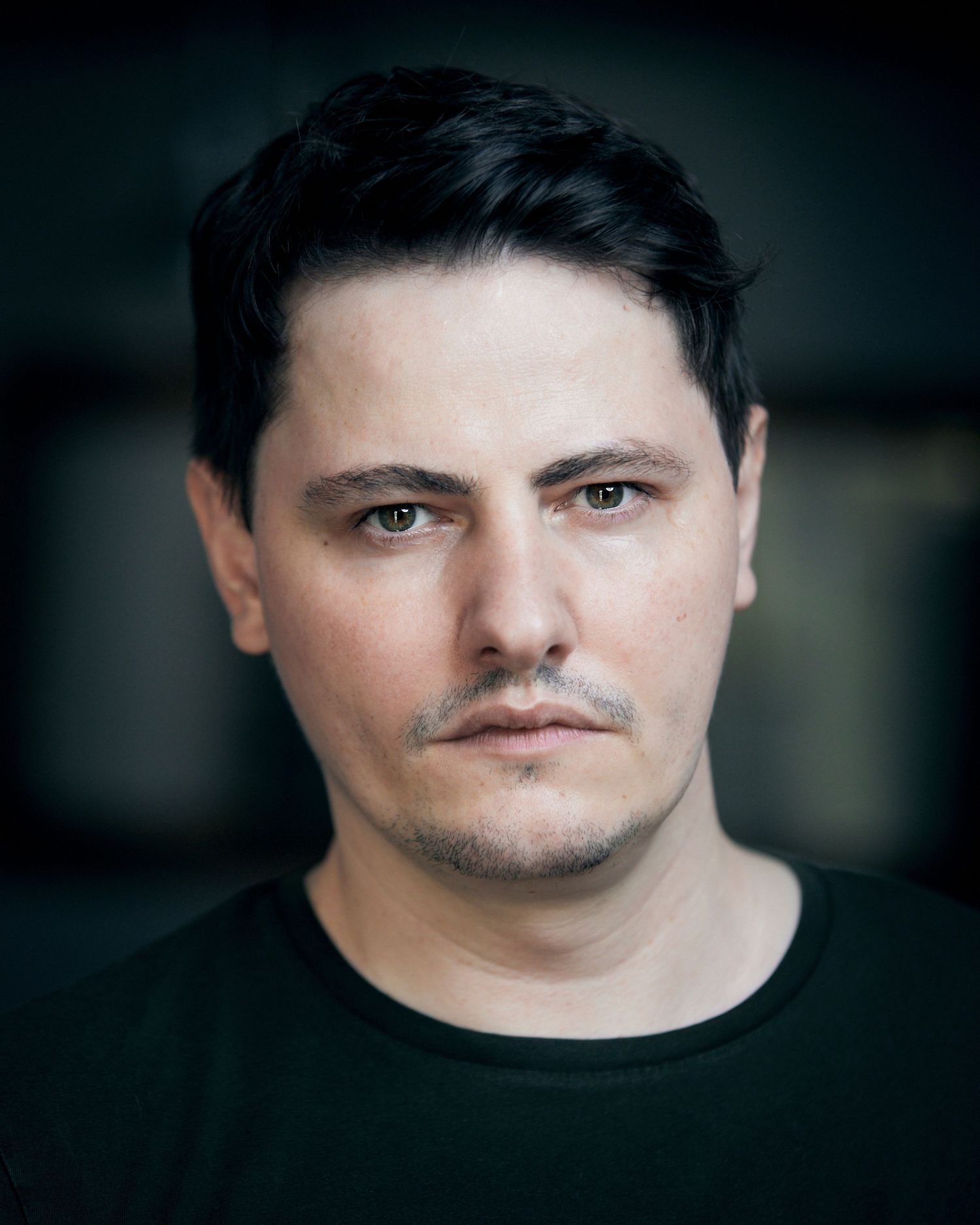 Cardiff outdoor headshot; gritty gaze in soft natural light bokeh.