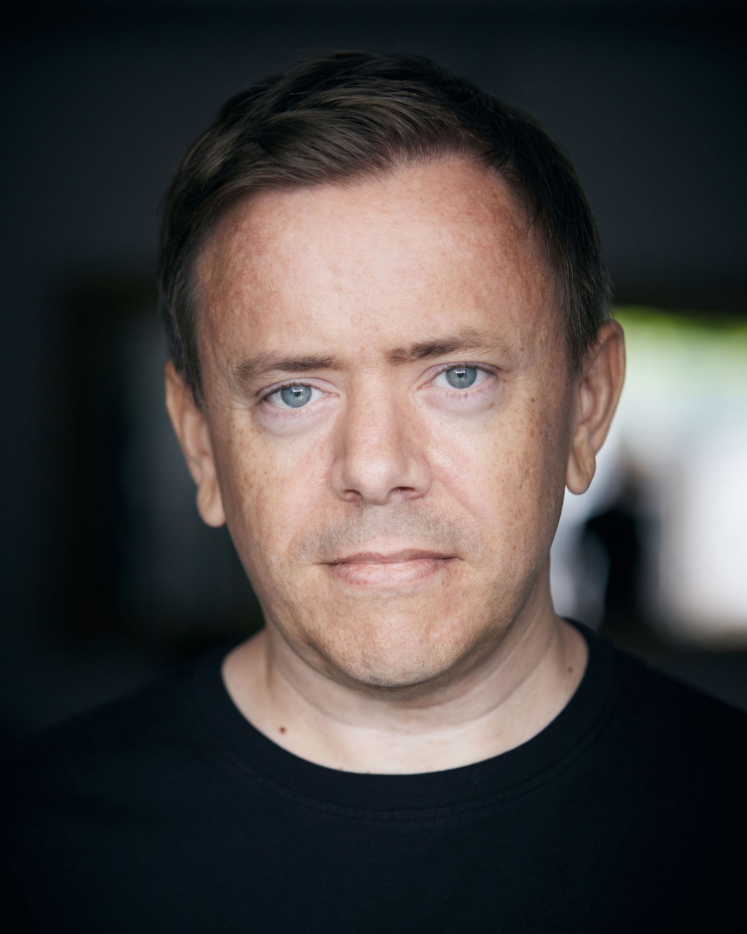 Clear-eyed direct headshot; charismatic look in Cardiff natural setting.