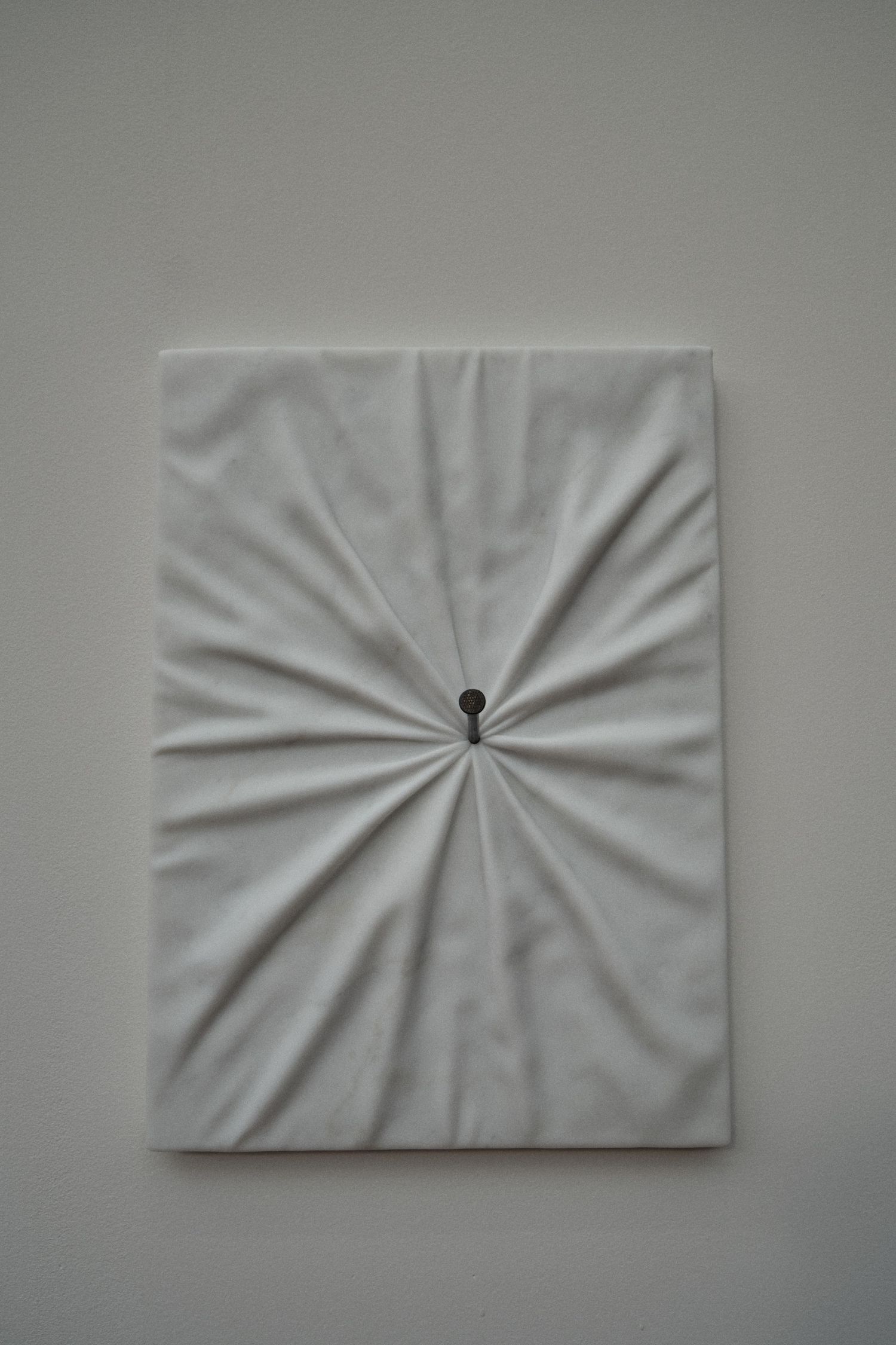 Minimalist marble canvas artwork with radial pleated pattern and central focal point.
