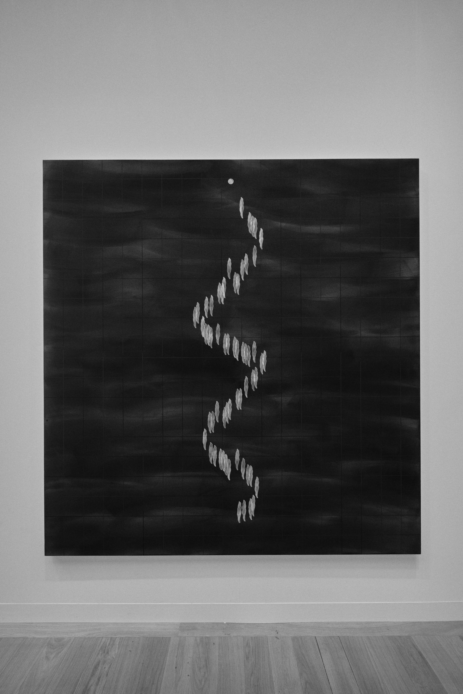 Minimalist black and white art installation showing descending figures on gallery wall.