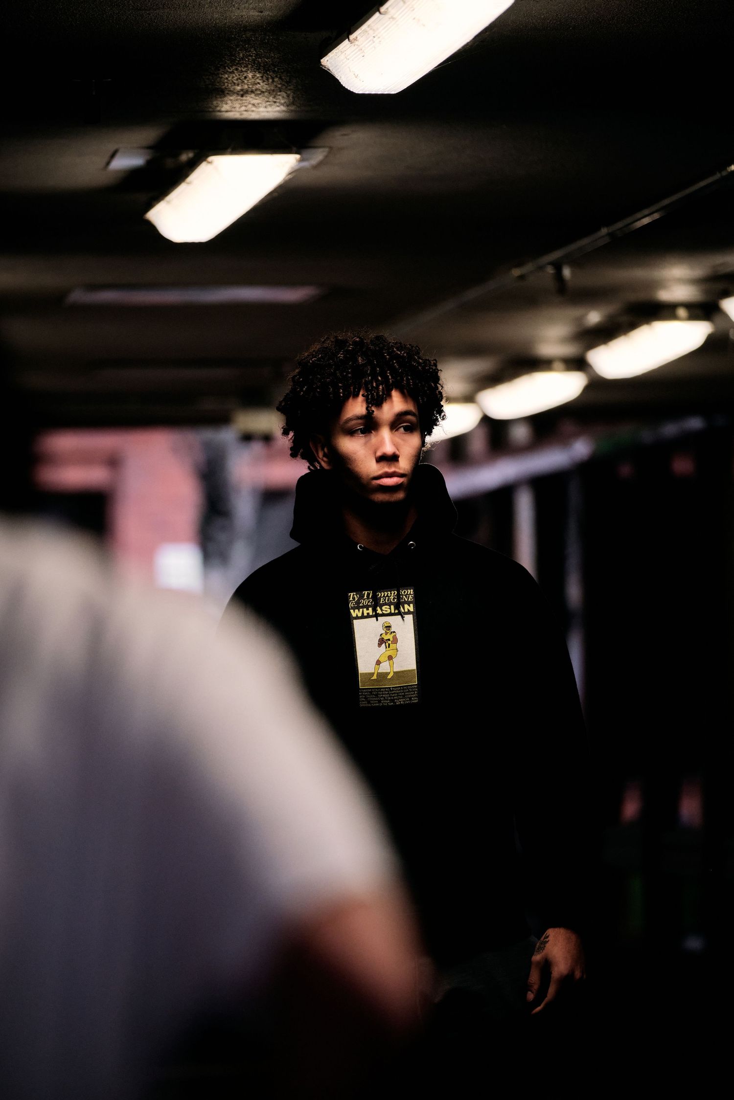 Person in dark clothing photographed in dimly lit indoor space.