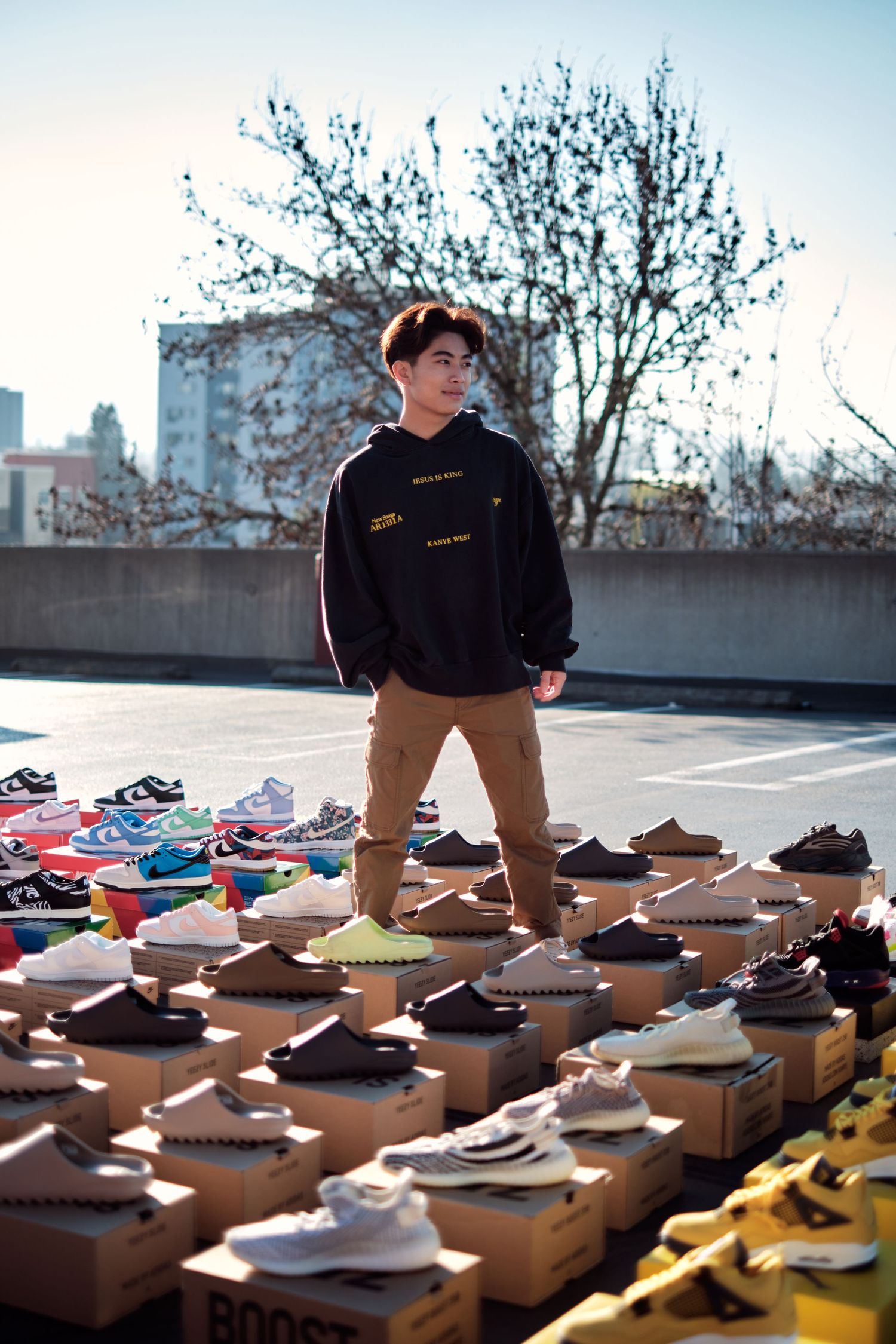 Sneakers arranged in rows on cardboard boxes during outdoor showcase.