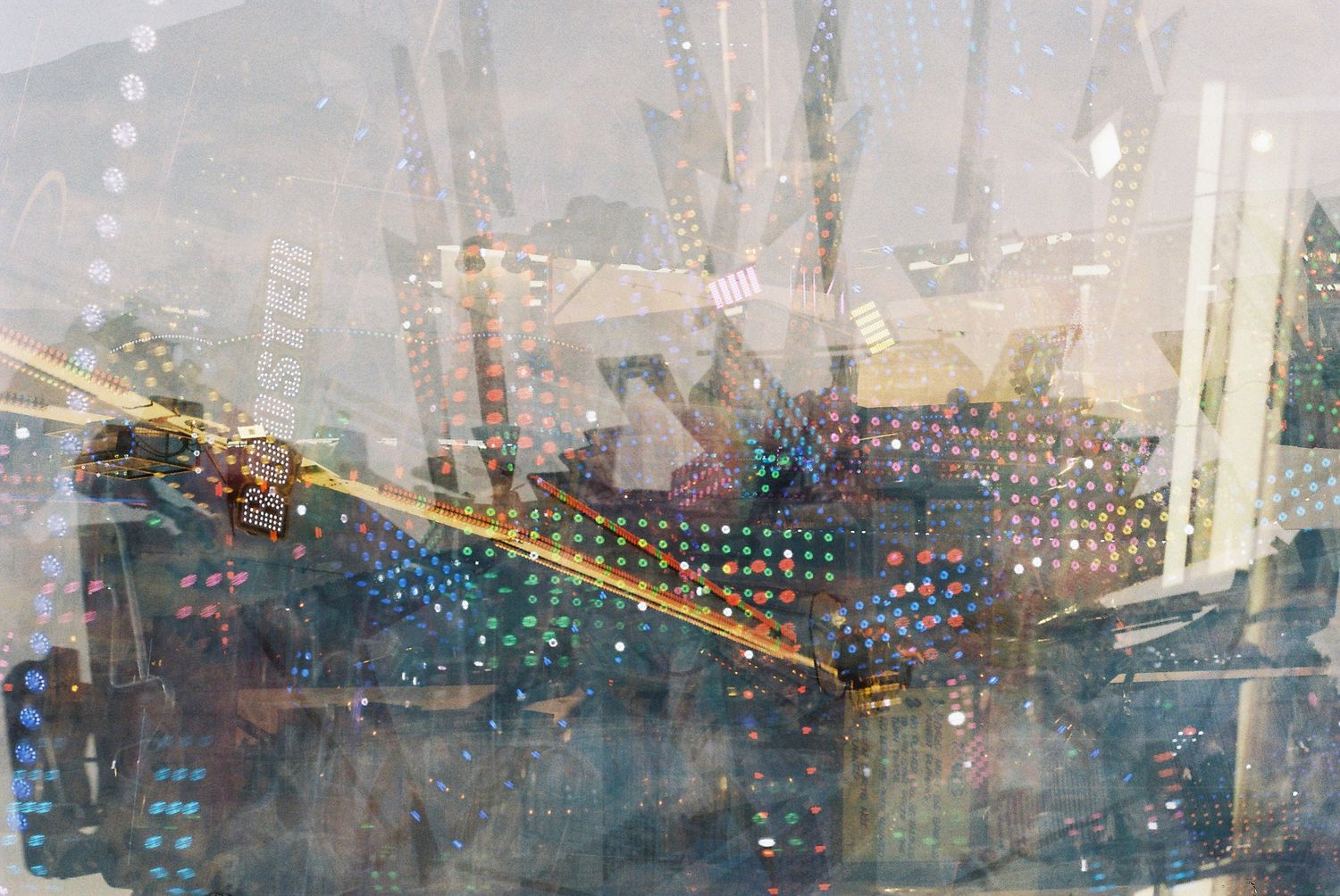 Cityscape reflected in rain-covered window with blurry buildings and lights visible through water droplets.