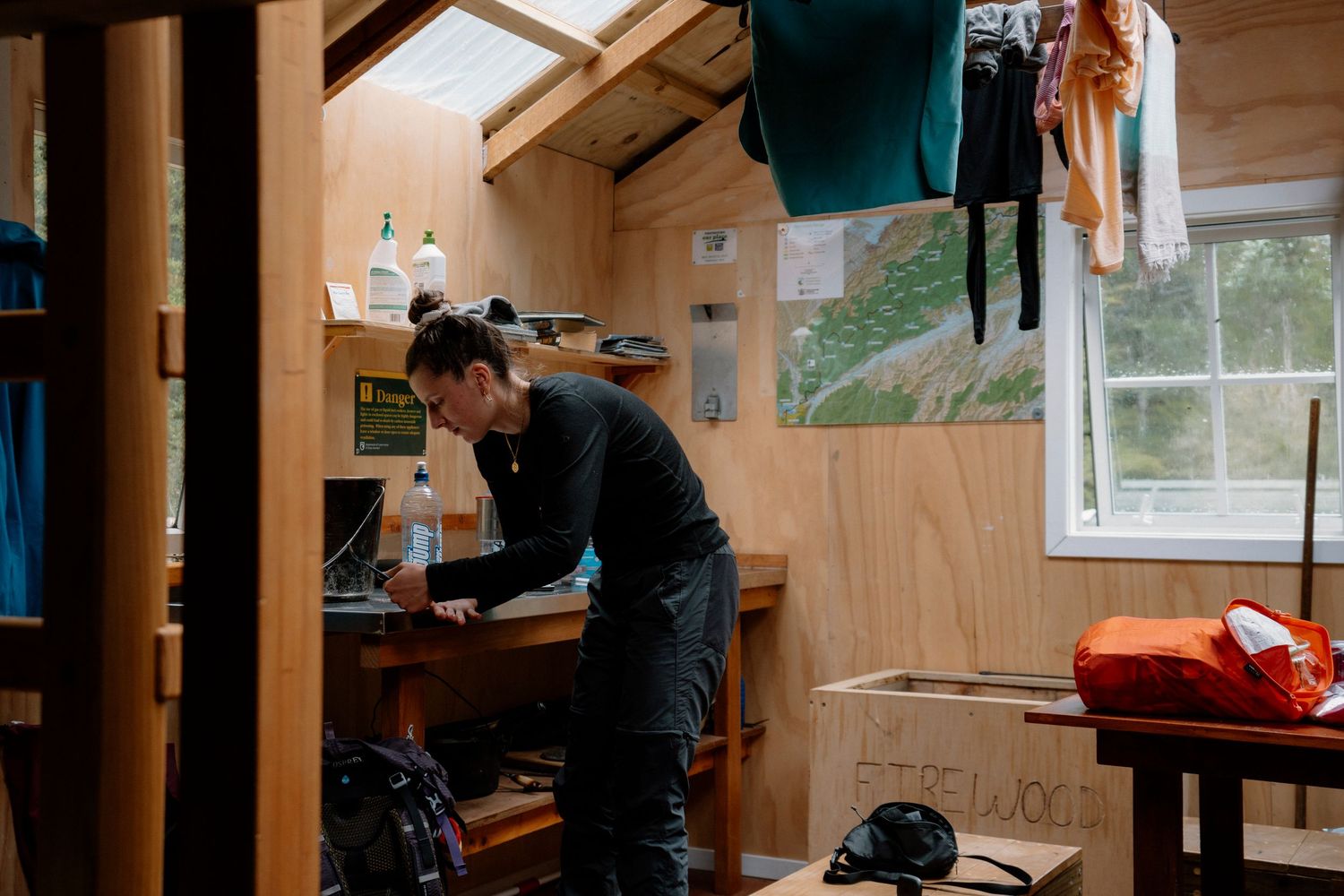 People working in a cozy wooden workshop with tools and equipment visible on the walls and workbenches.