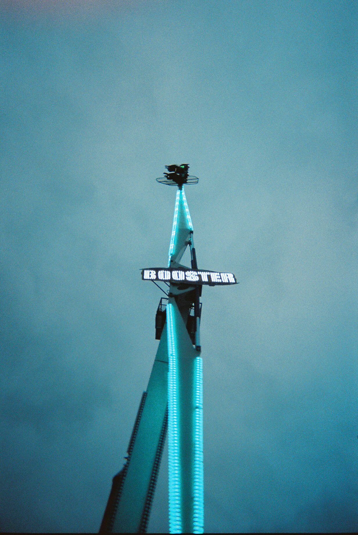 A time-lapse sequence showing the construction progress of a tall building with blue illuminated lights against a dusky sky.