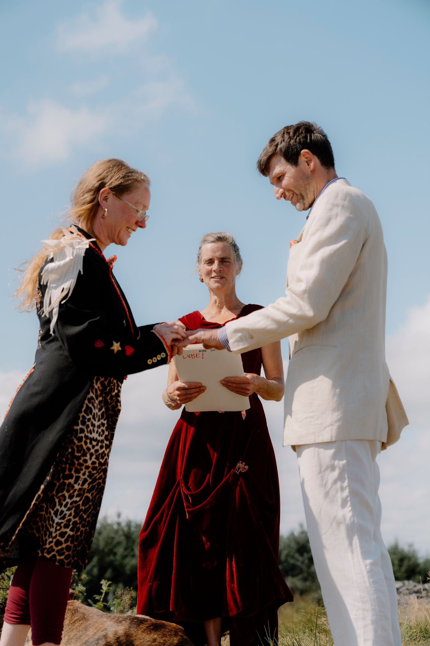 Wedding party members participate in outdoor ceremony rituals.
