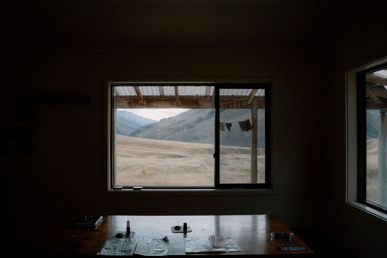 A panoramic sequence of dark interior views through windows showing mountains, water, and natural landscapes in the distance.