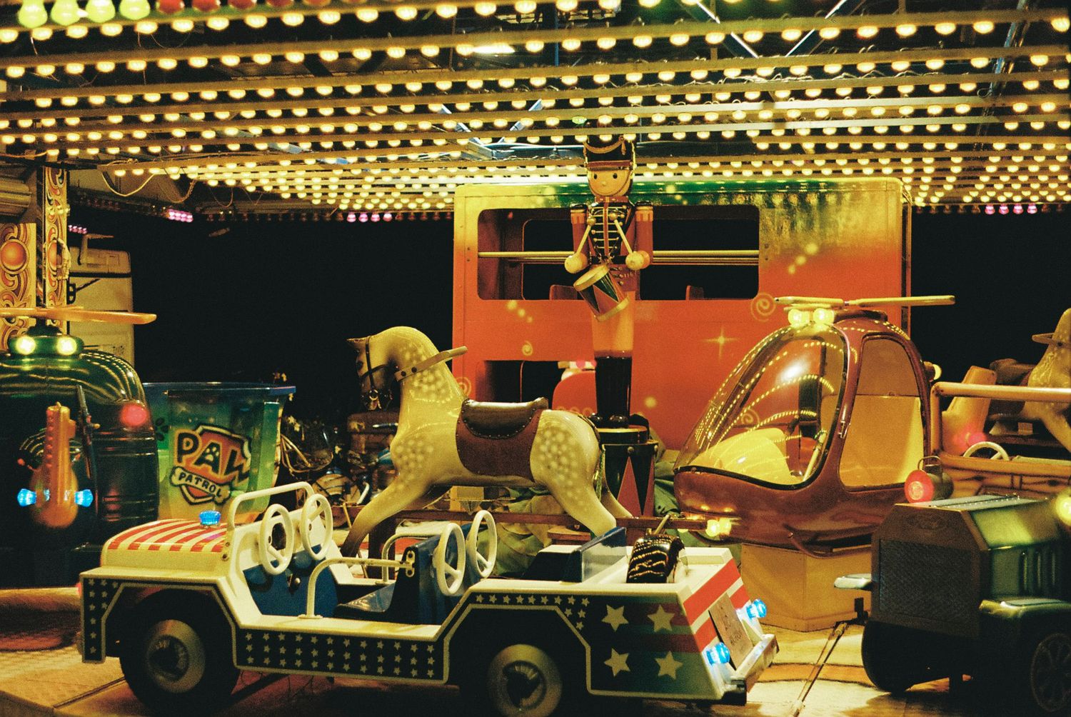 A series of vintage cars and classic automobiles on display in a museum with warm lighting and retro decor.