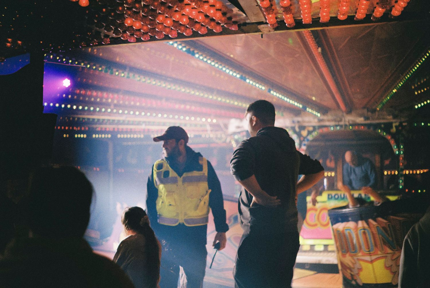 Silhouetted figures dance and party under colorful nightclub lighting with fog and disco effects.