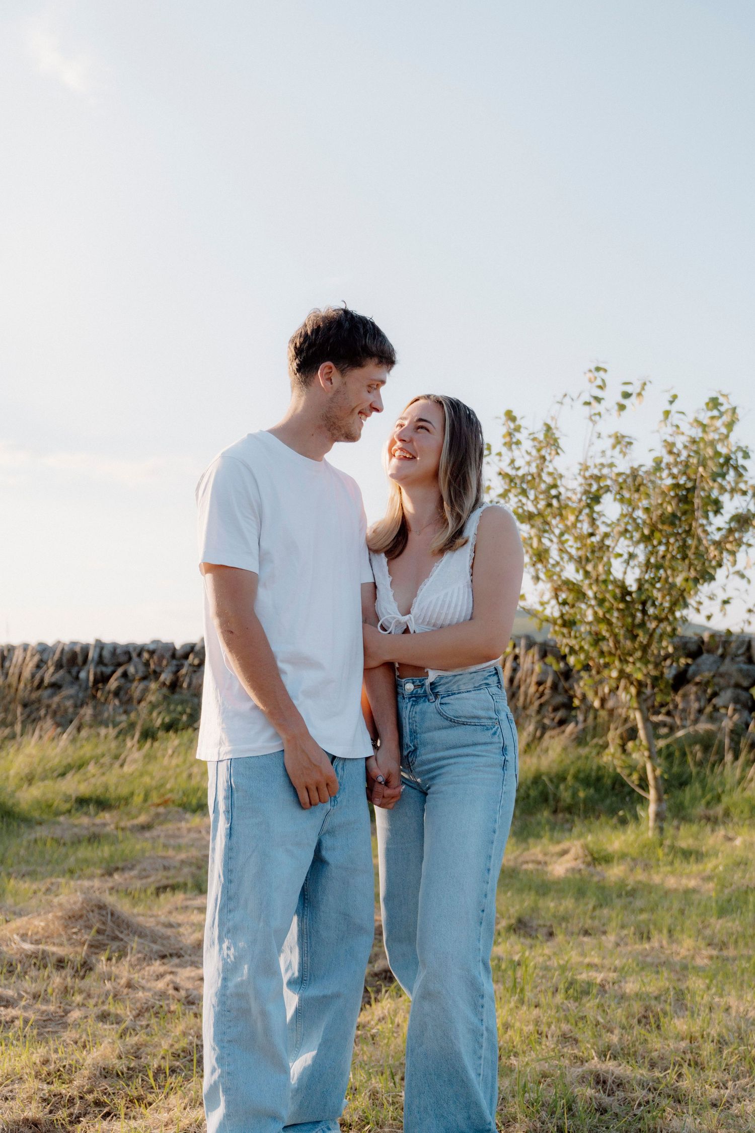 Casual couple portraits in denim against a natural summer landscape.