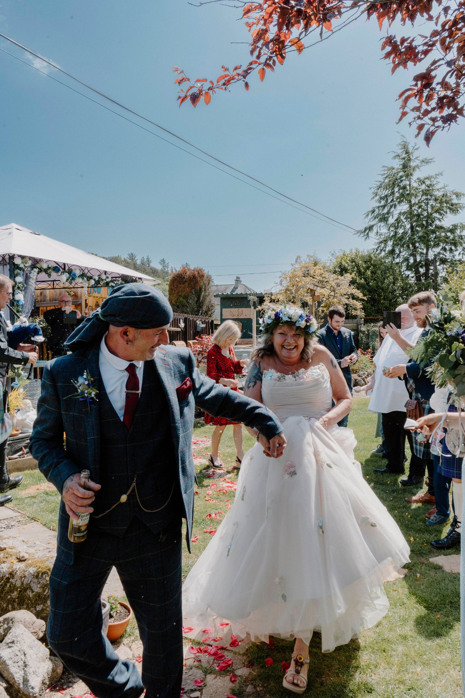 A couple dances together at an outdoor garden wedding celebration.